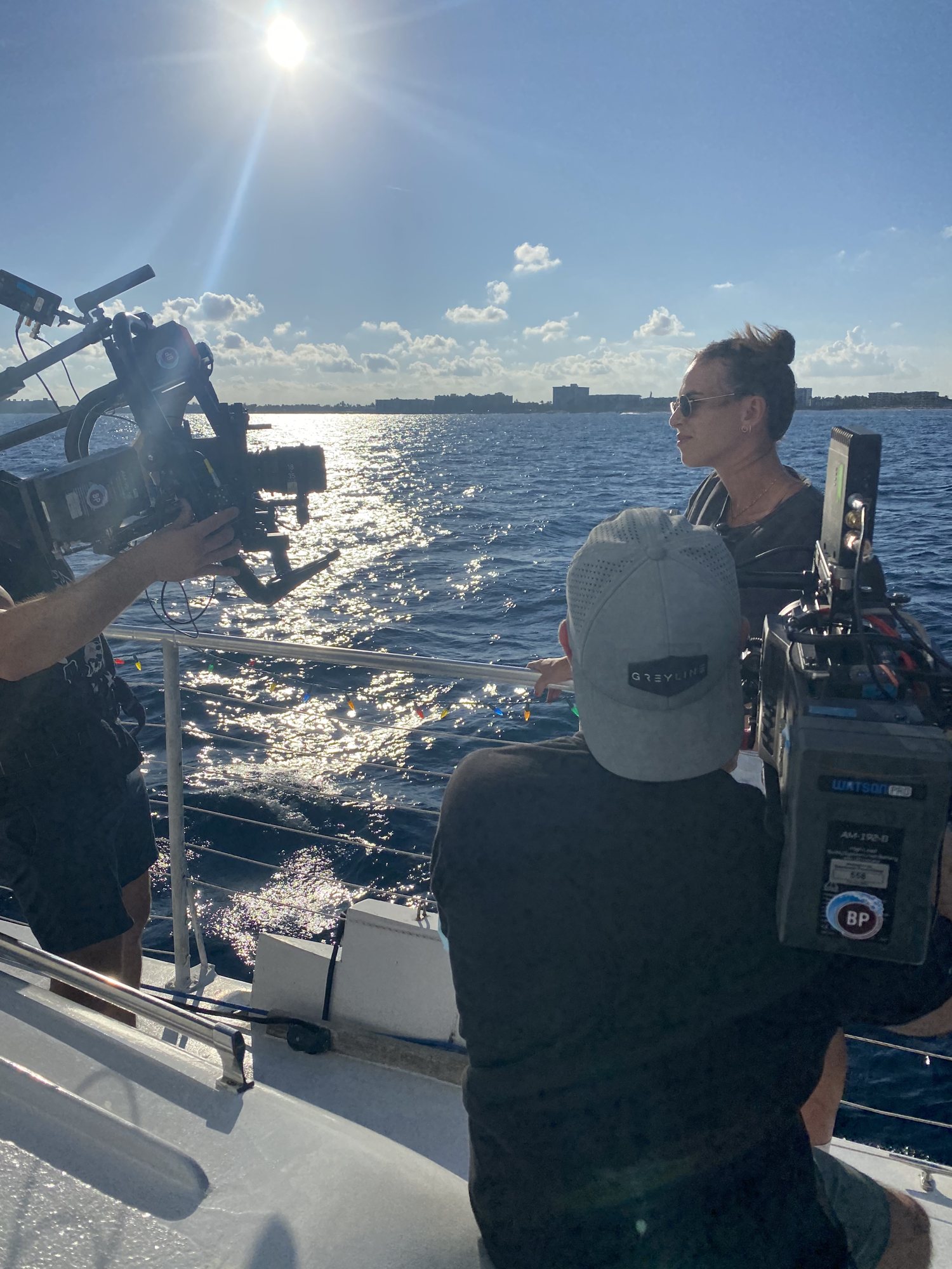 Greyline Media crew filming on a moving boat on open water
