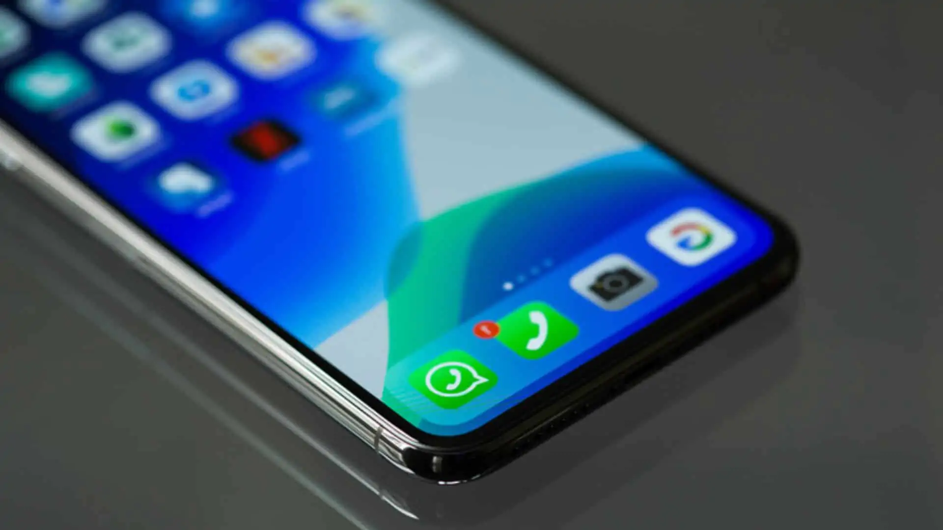 Uma mão segurando um celular que está tirando foto de um Supermercado.