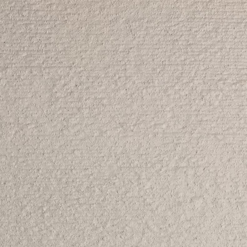 Close-up of a rough textured surface in a light beige color resembling stucco or cement.