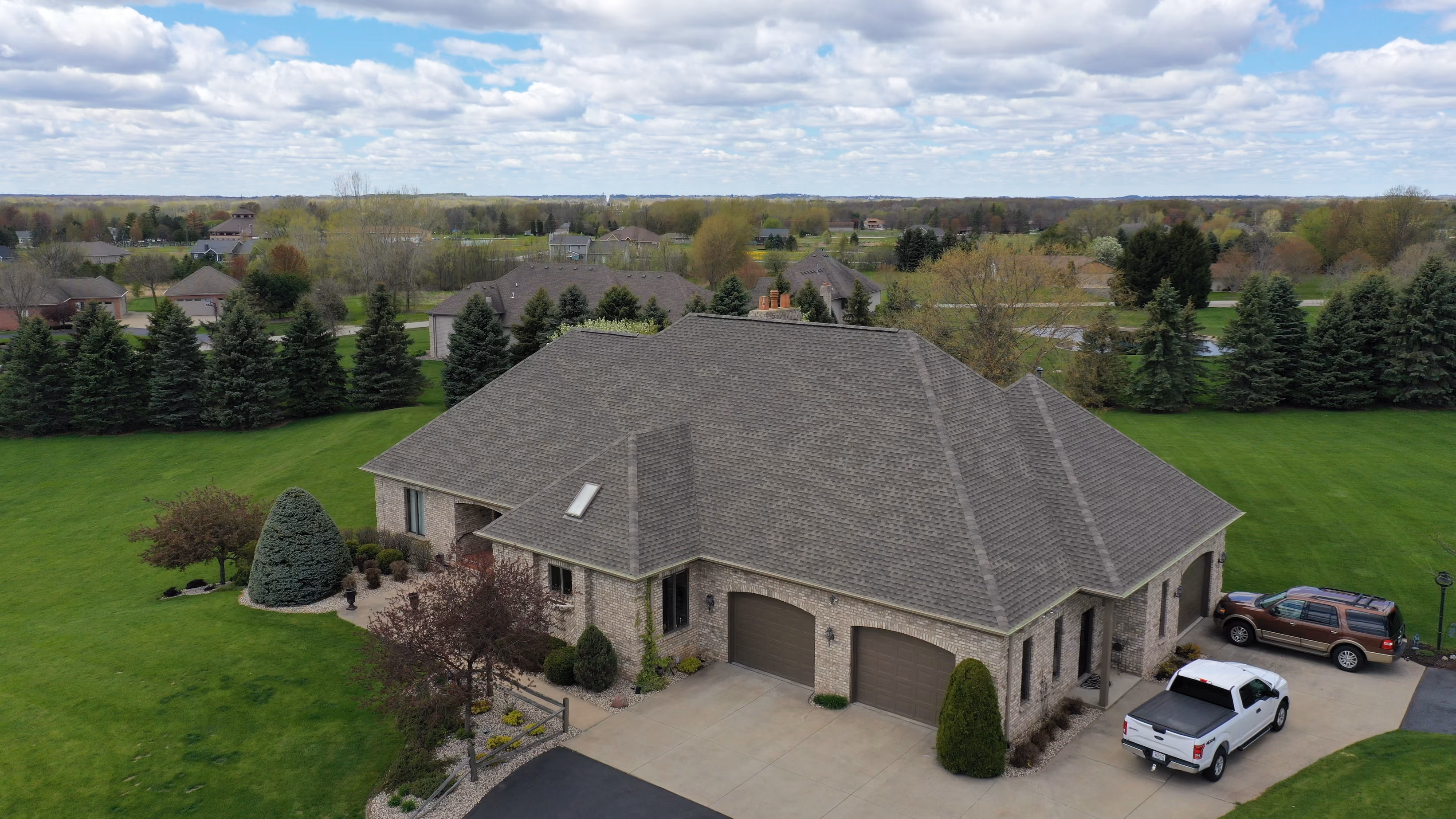 Aerial view of a large Appleton home with a gray asphalt shingle roof and green lawn