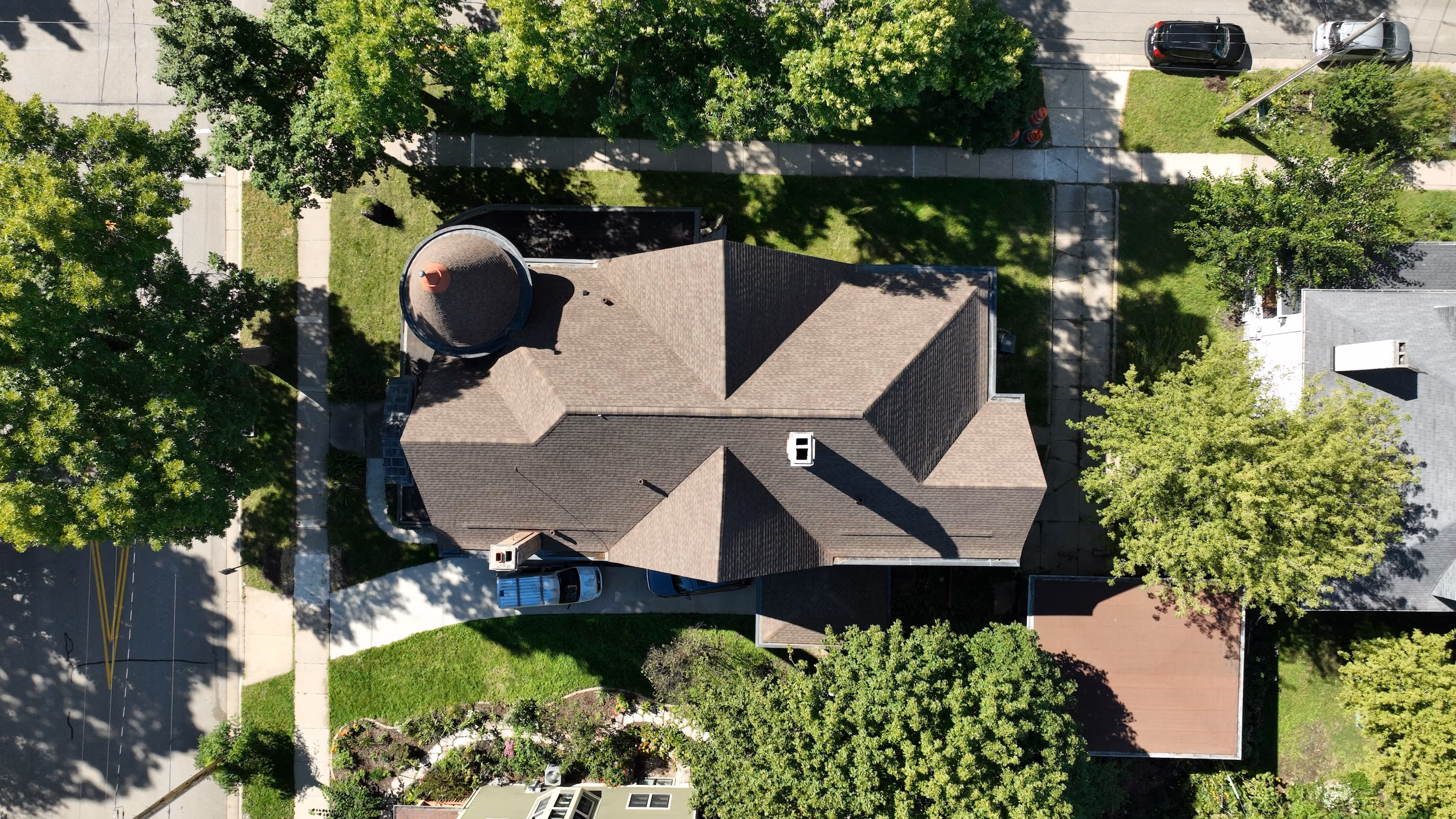 Aerial view of an Appleton home with a brown asphalt shingle roof surrounded by mature trees