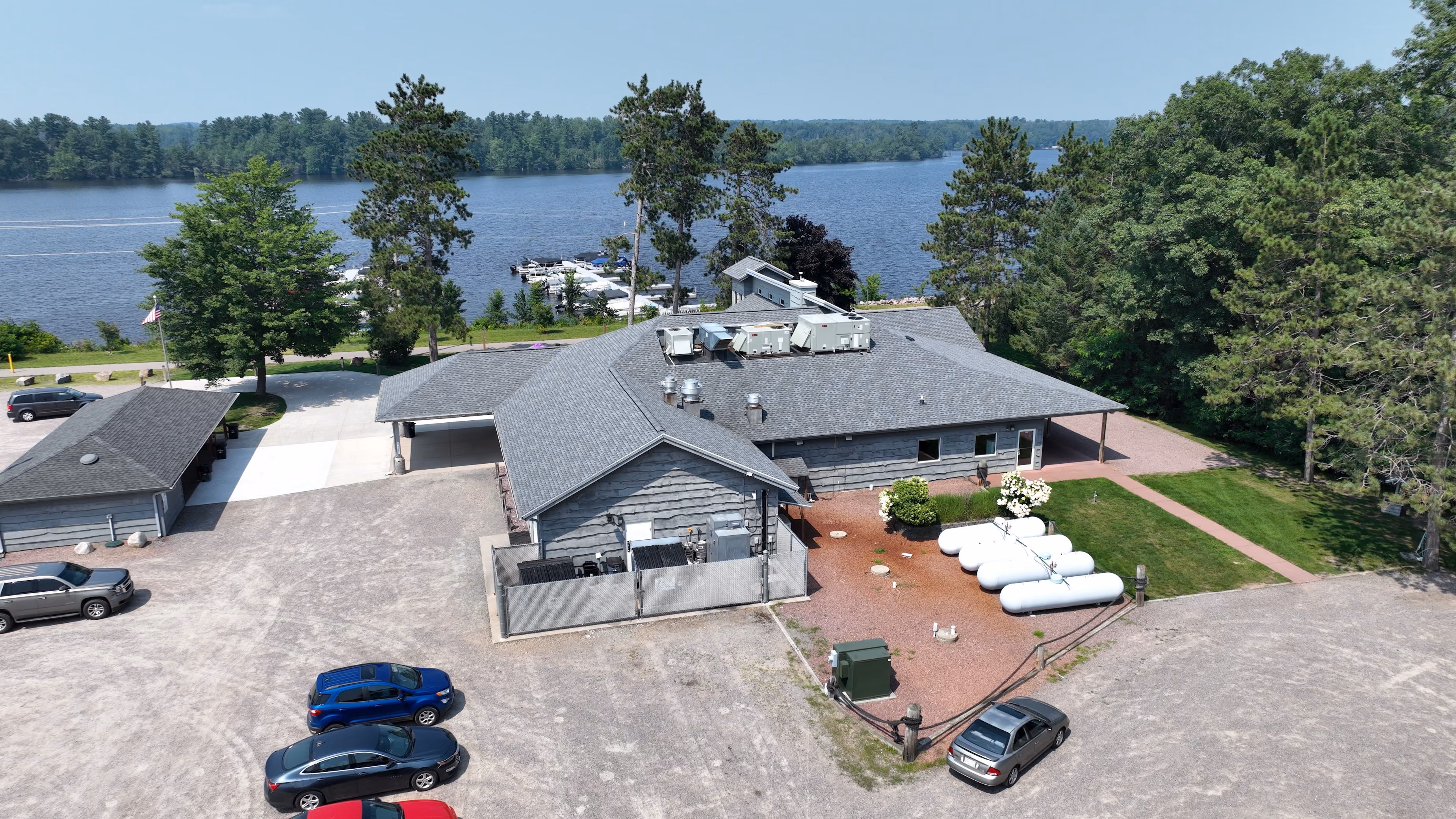 Aerial view of a Wisconsin Rapids lakefront home with a gray asphalt shingle roof