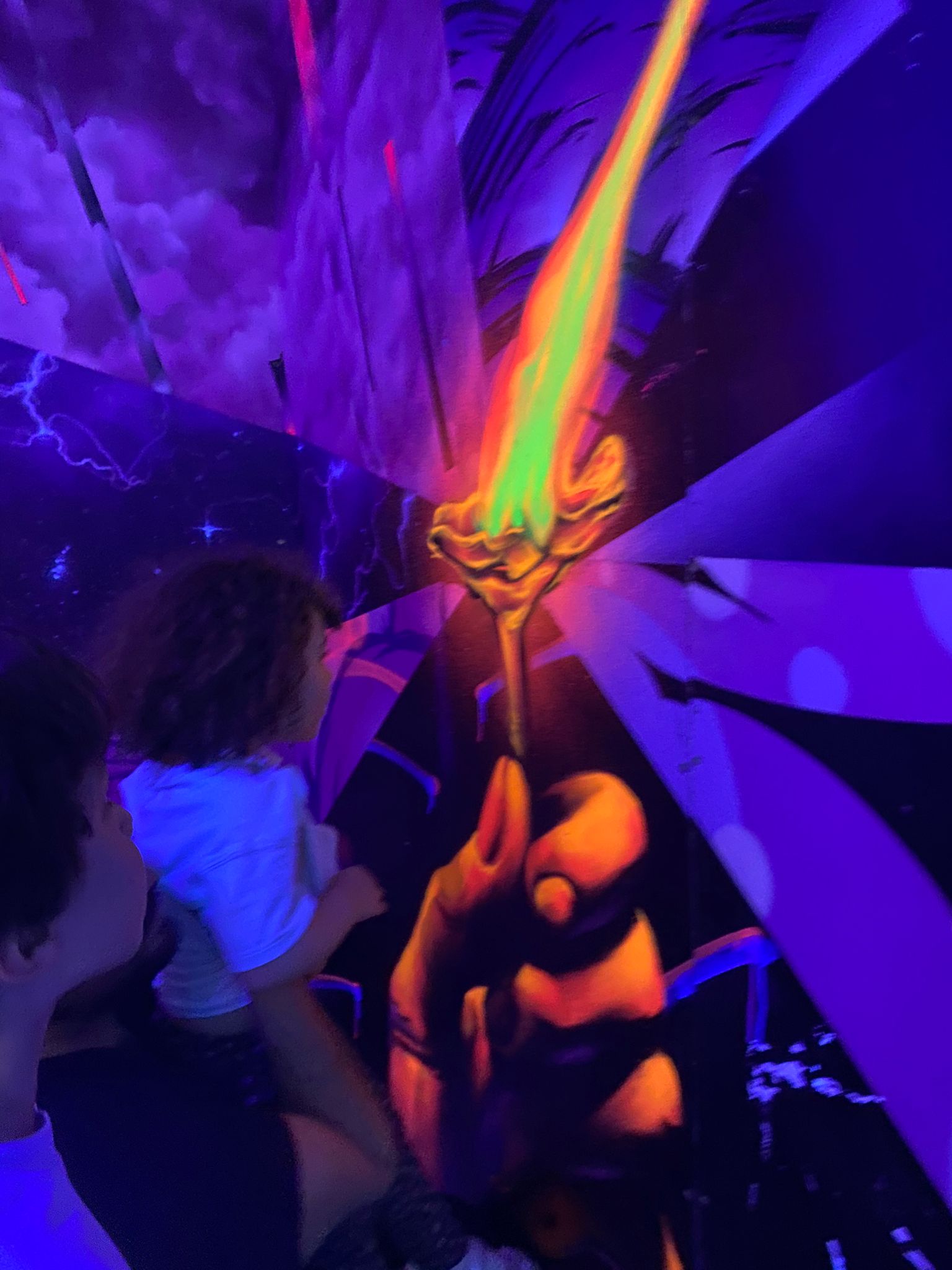 Enfant qui touche une œuvre néon
