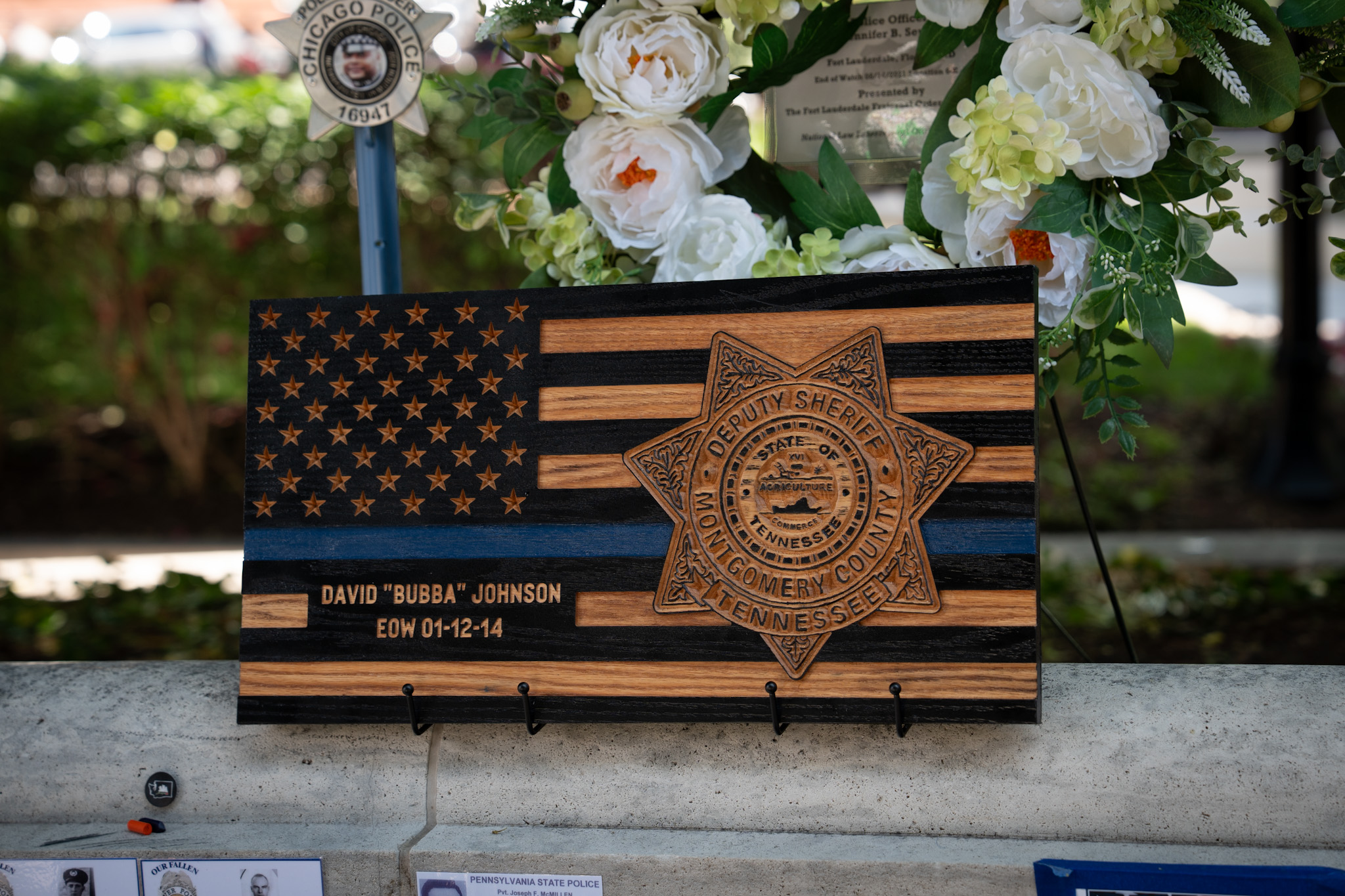 Wooden memorial flag with blue stripe and Montgomery County Deputy Sheriff badge for David Bubba Johnson.