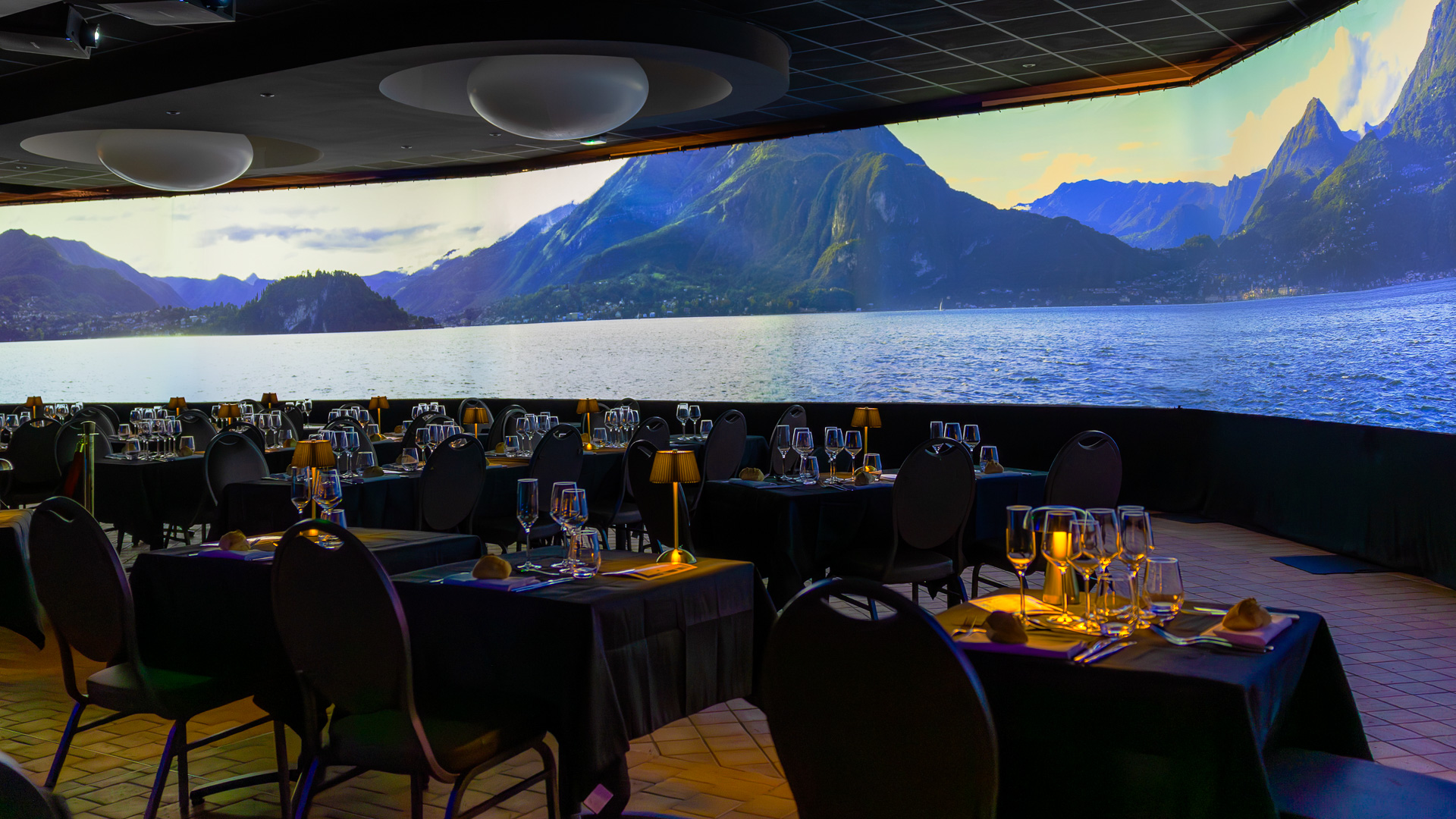 Repas immersif La Porte des Mondes : écran panoramique et convives attablés, soirée d'entreprise au Domaine de Chatillon près d'Angers