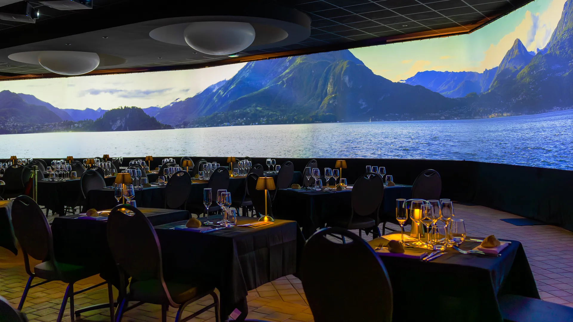 Repas immersif La Porte des Mondes : écran panoramique et convives attablés, soirée d'entreprise au Domaine de Chatillon près d'Angers