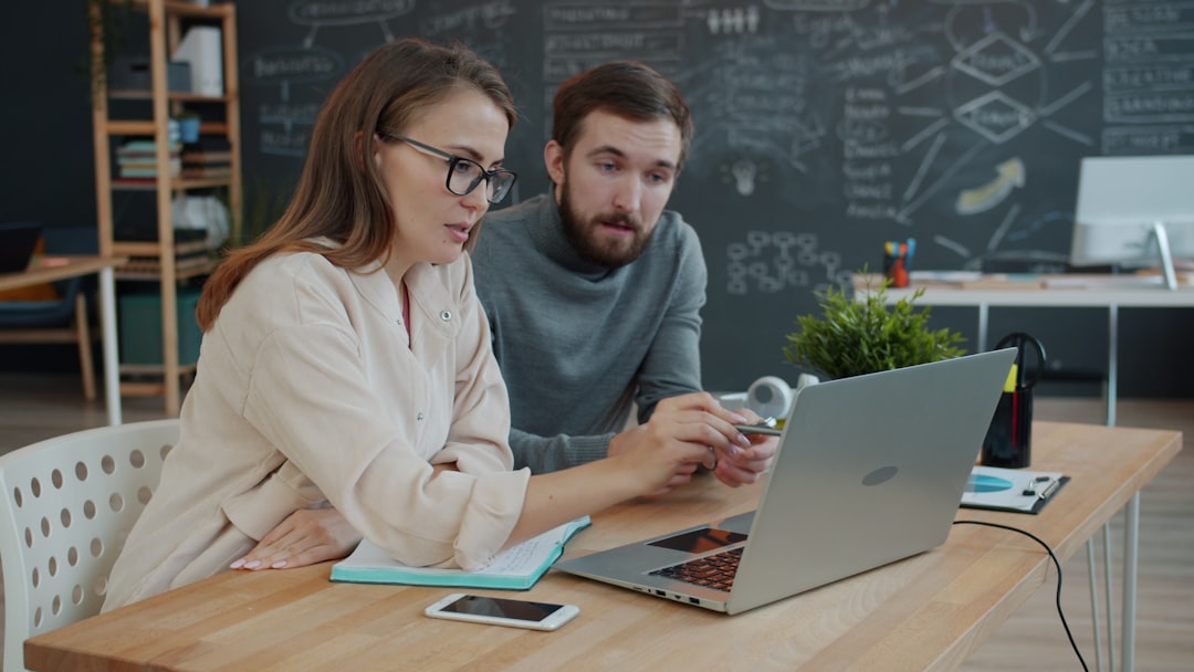 Two colleagues collaborating on a project at a laptop