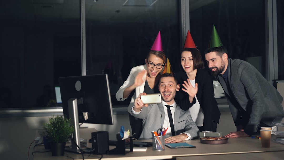 Colleagues celebrating with party hats taking a selfie