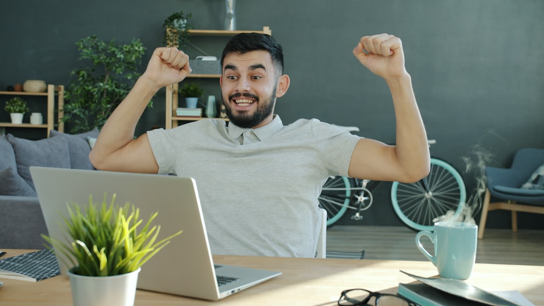 Man celebrating success while working on laptop