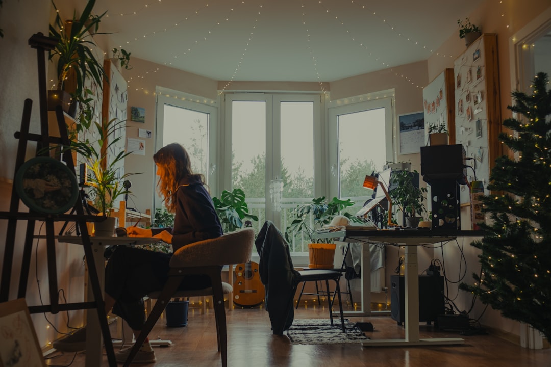 Woman working at a desk in a cozy, plant-filled room