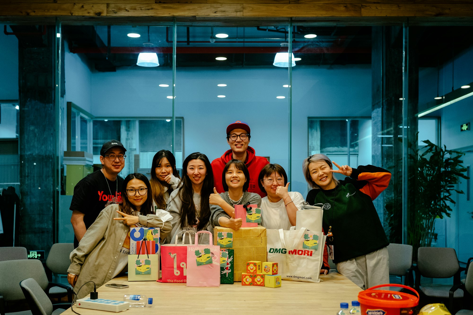 A group of people standing around a table in a corporate team building event. Photo by tommao wang on Unsplash