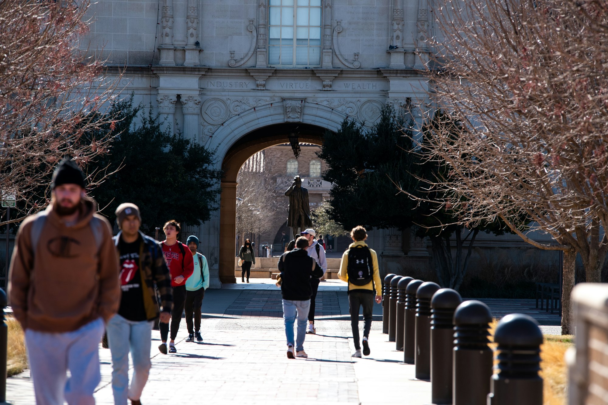 Students walking through a university campus archway. Photo by Brelyn Bashrum on Unsplash