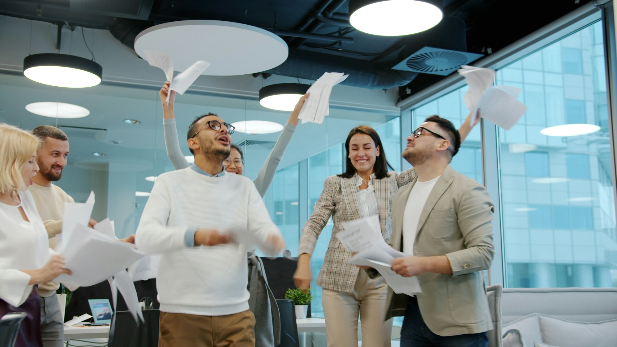 Diverse team celebrating by throwing papers in office. Photo by Vitaly Gariev on Unsplash