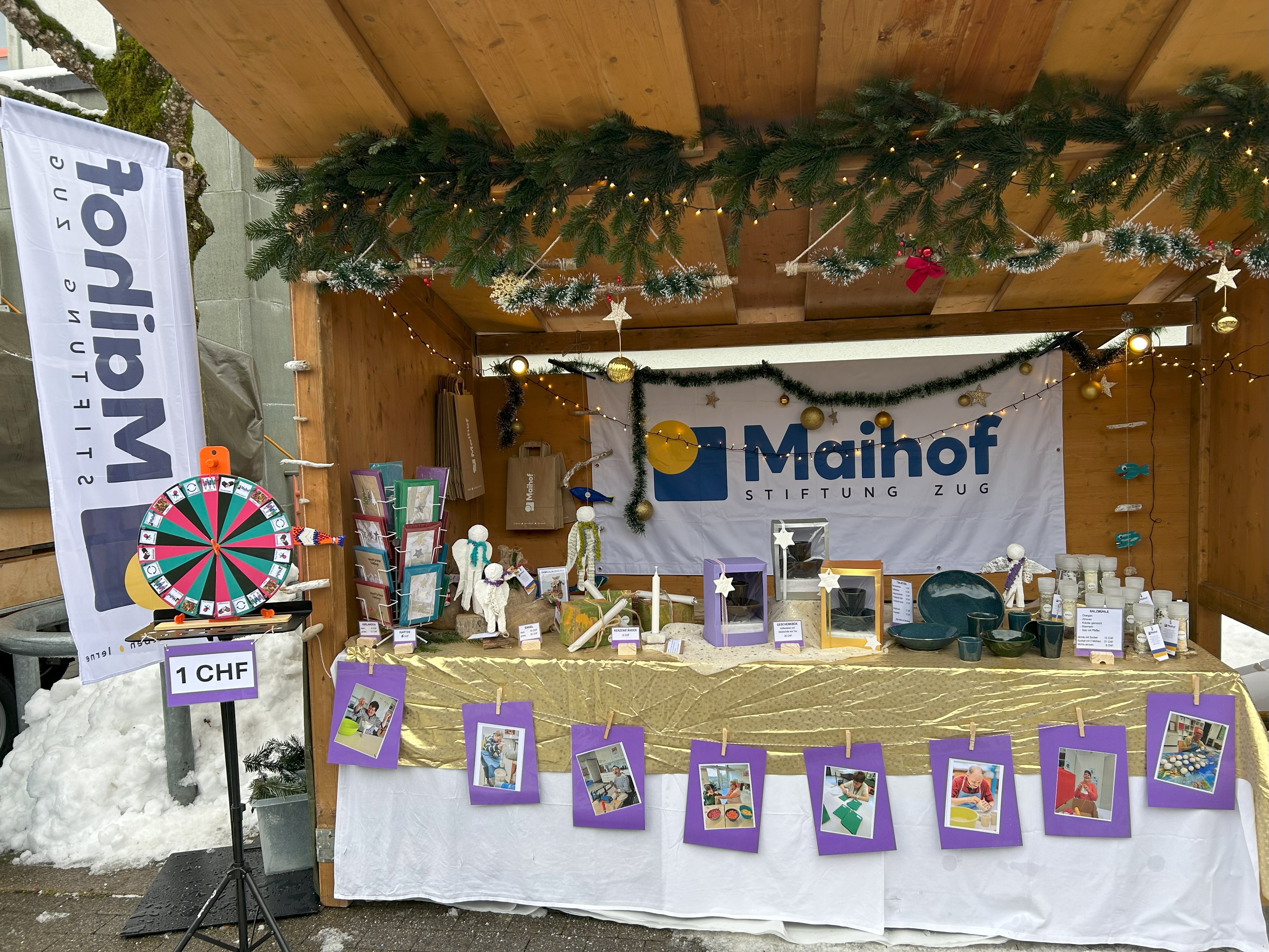 Weihnachtsmarktstand der Stiftung Maihof mit Kunsthandwerk, Karten und Glücksrad
