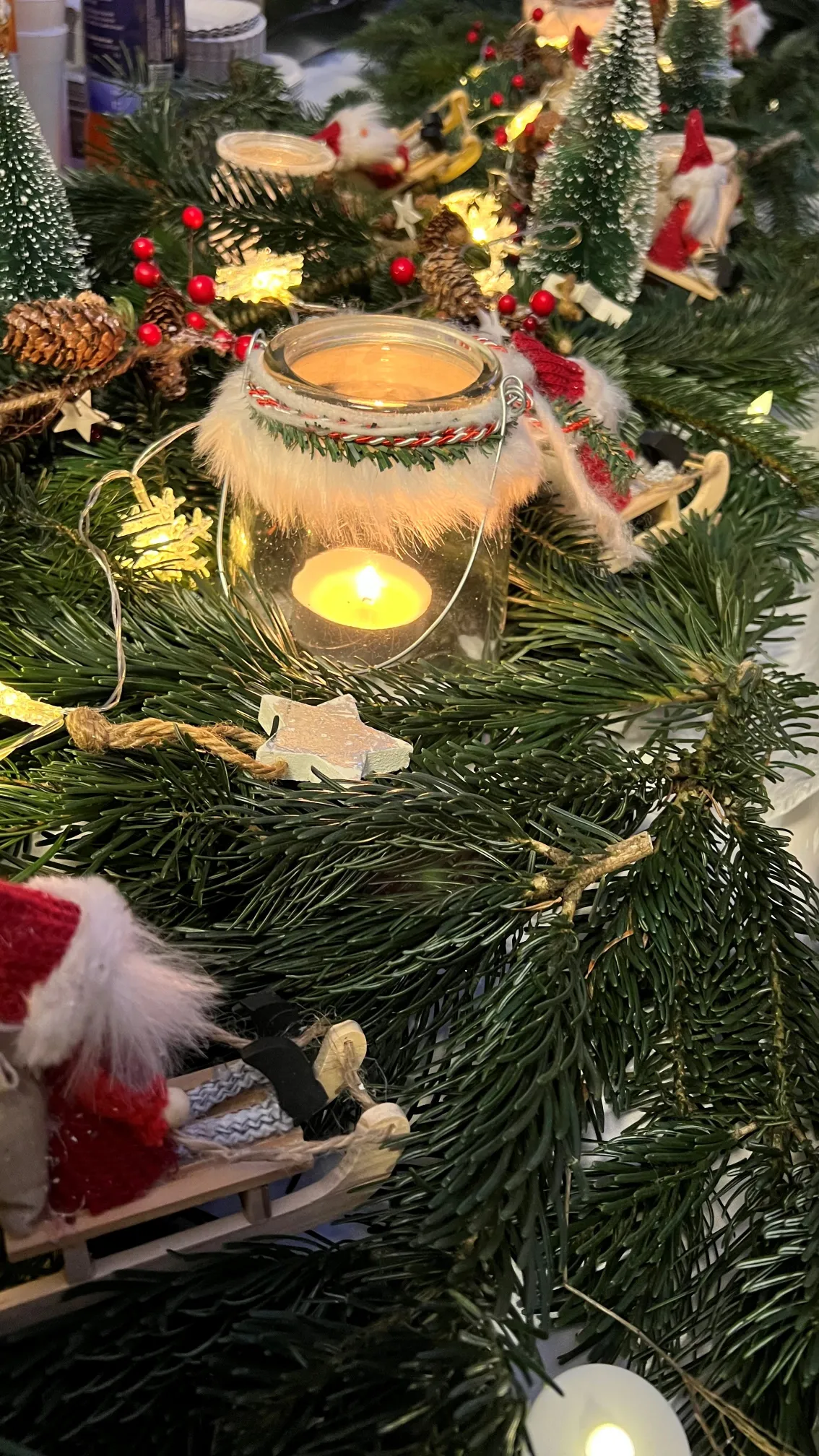 Weihnachtliches Gesteck mit Windlicht und Tannenzweigen
