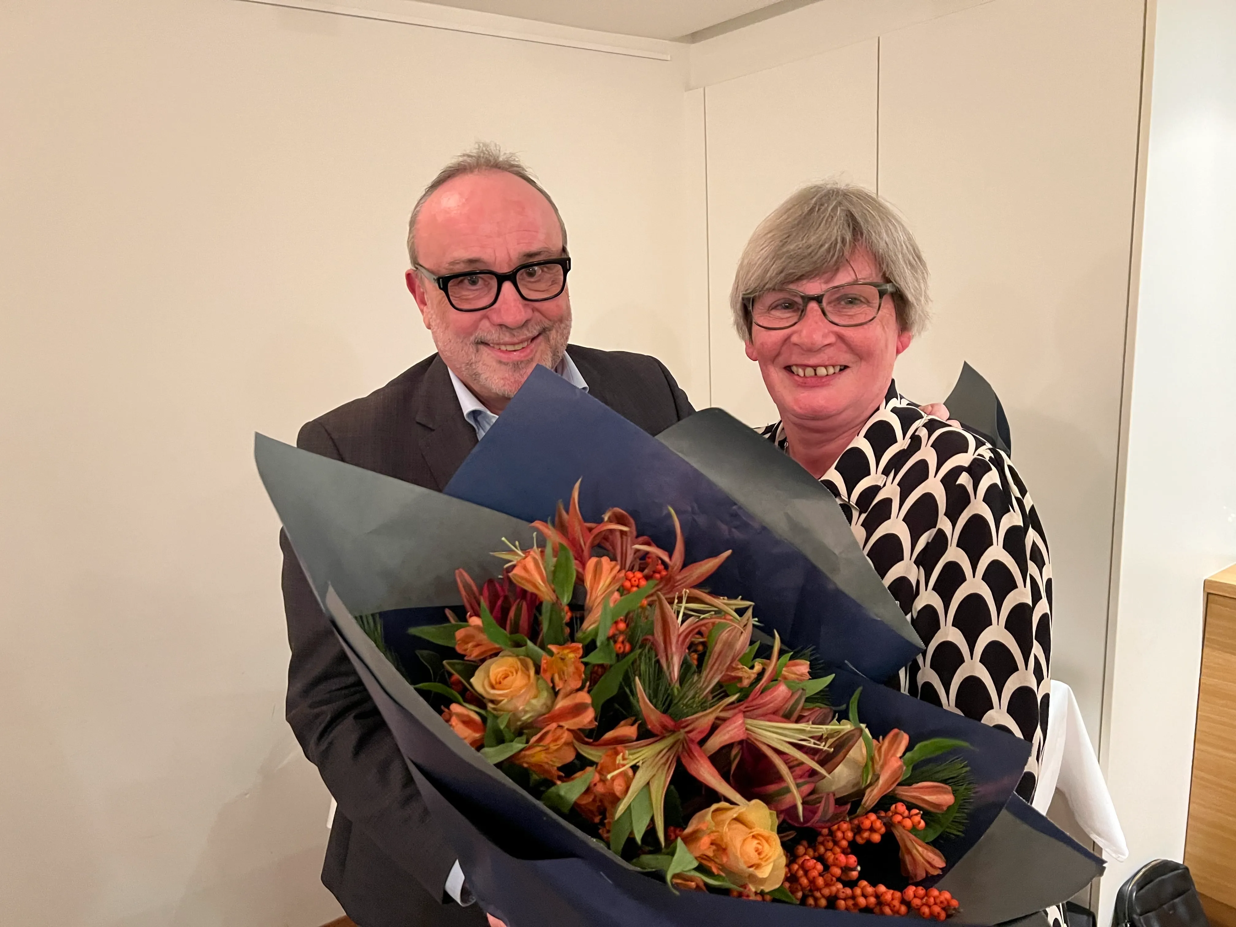 Mann und Frau mit grossem Blumenstrauss beim Wechsel im Stiftungsrat