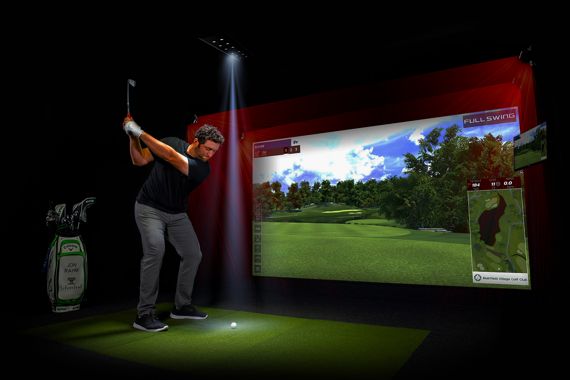 Golfer mid-swing in a Full Swing simulator bay