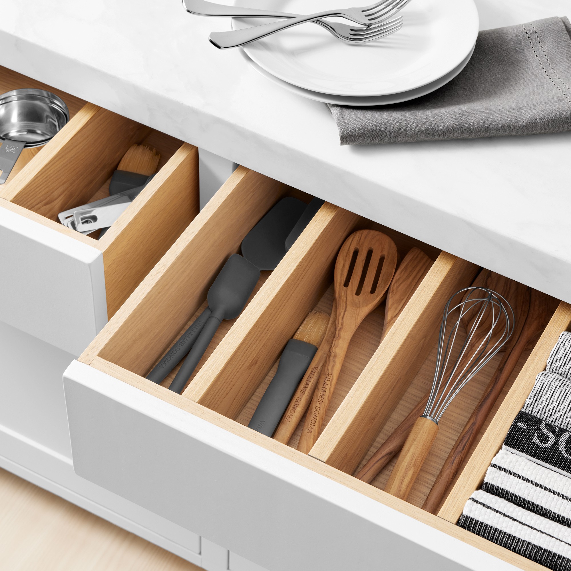 An open kitchen drawer with utensils.