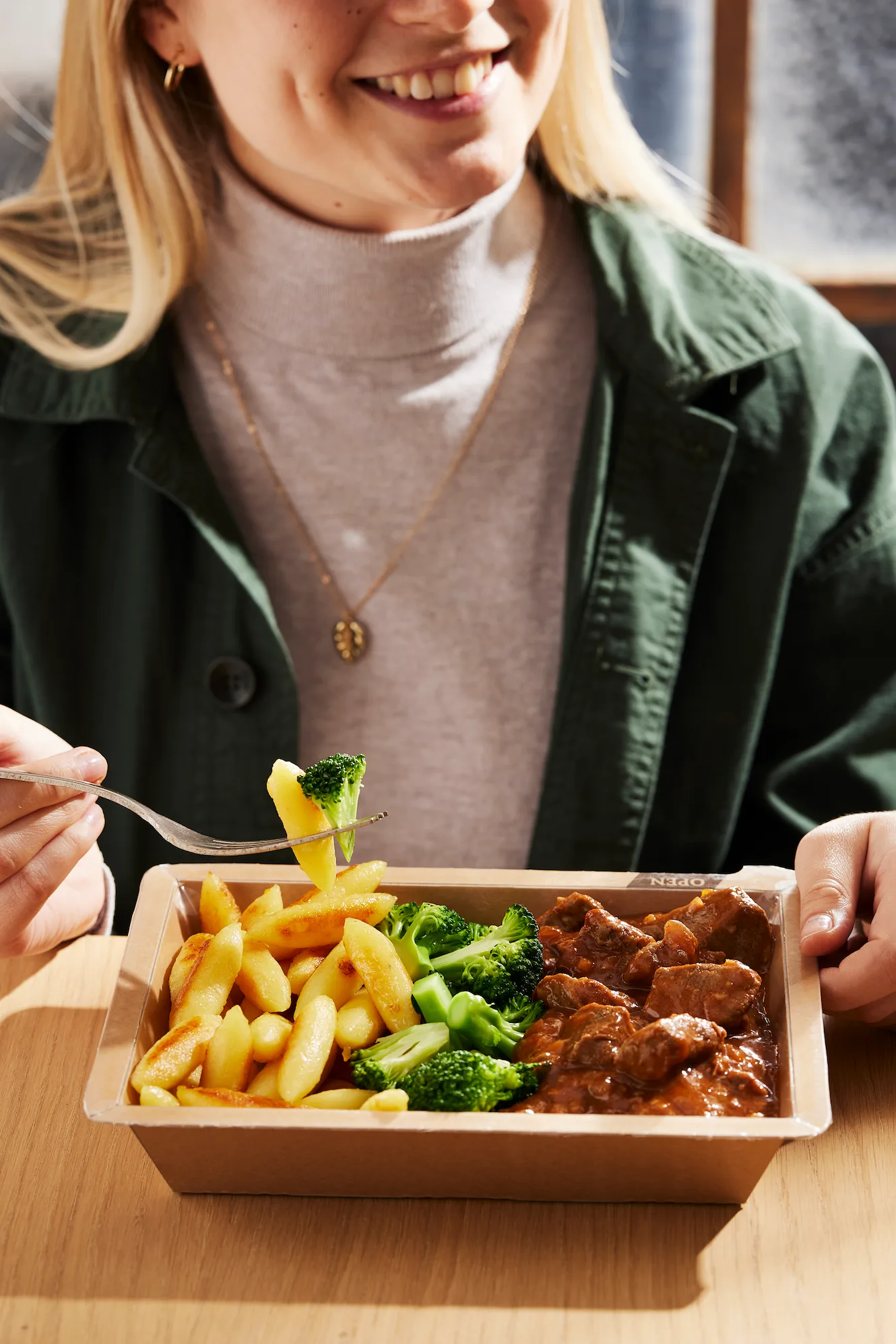 Frau snackt Essen aus modernem Kühlschrank
