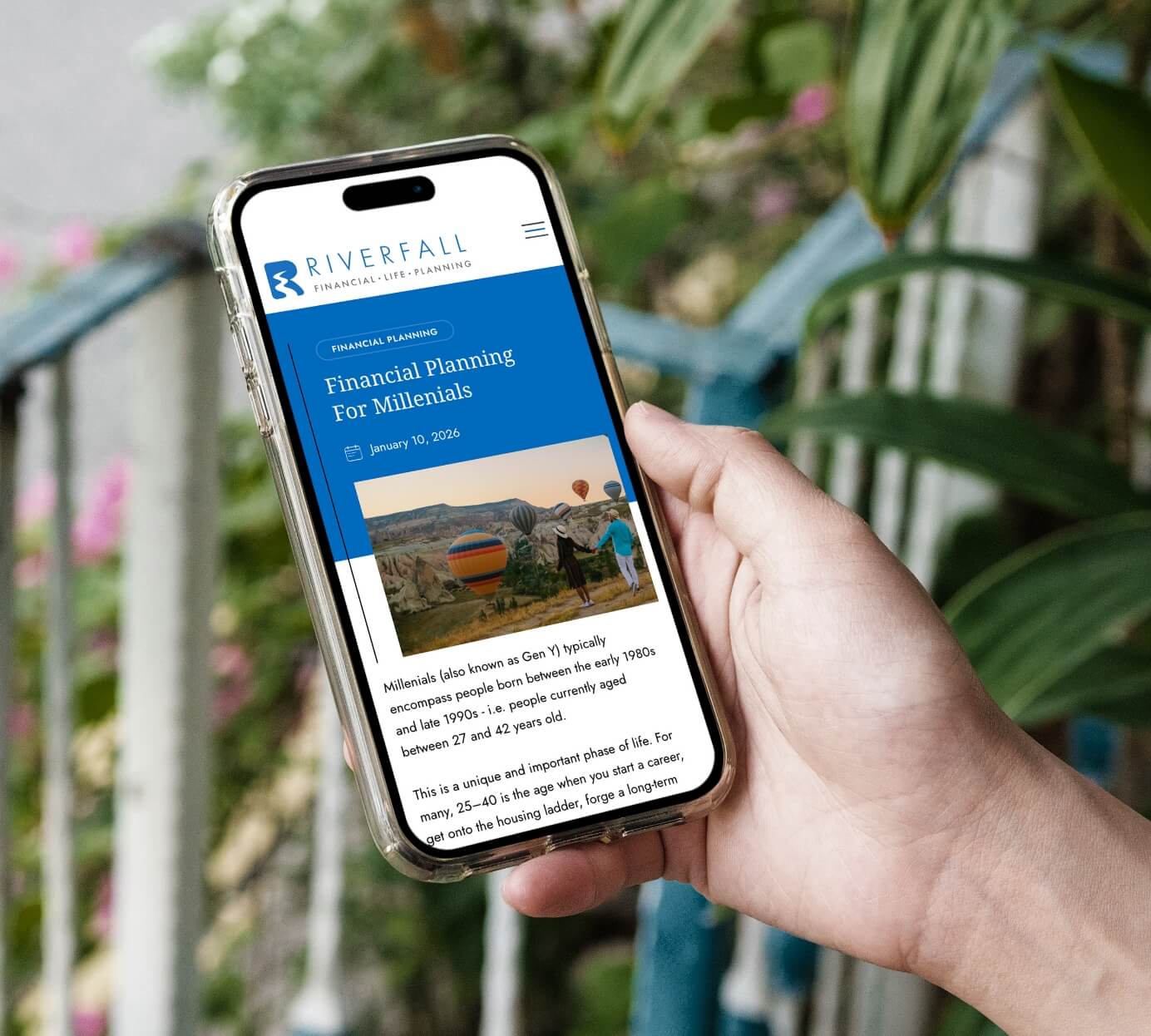 Hand holding iphone 16 displaying a mockup of a Riverfall Newsletter.