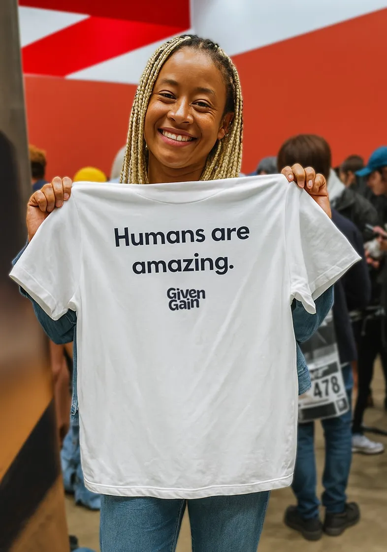 Woman holding a teeshirt with the GivenGain logo