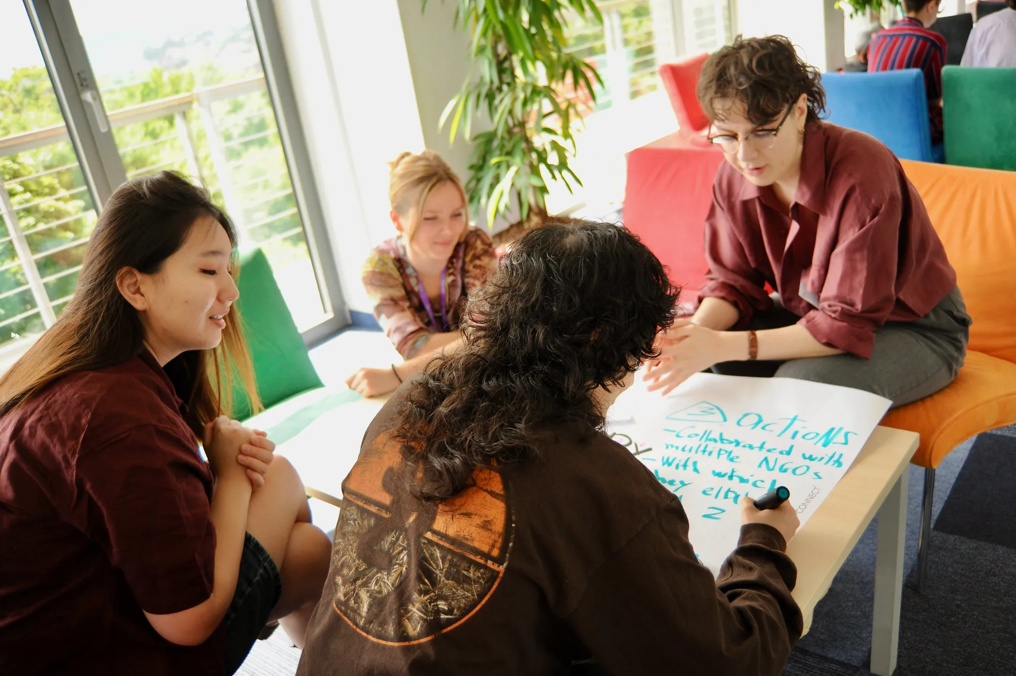 Photo of four participants working around a flipchart at the IGLYO Study Session on Rural Inclusion.