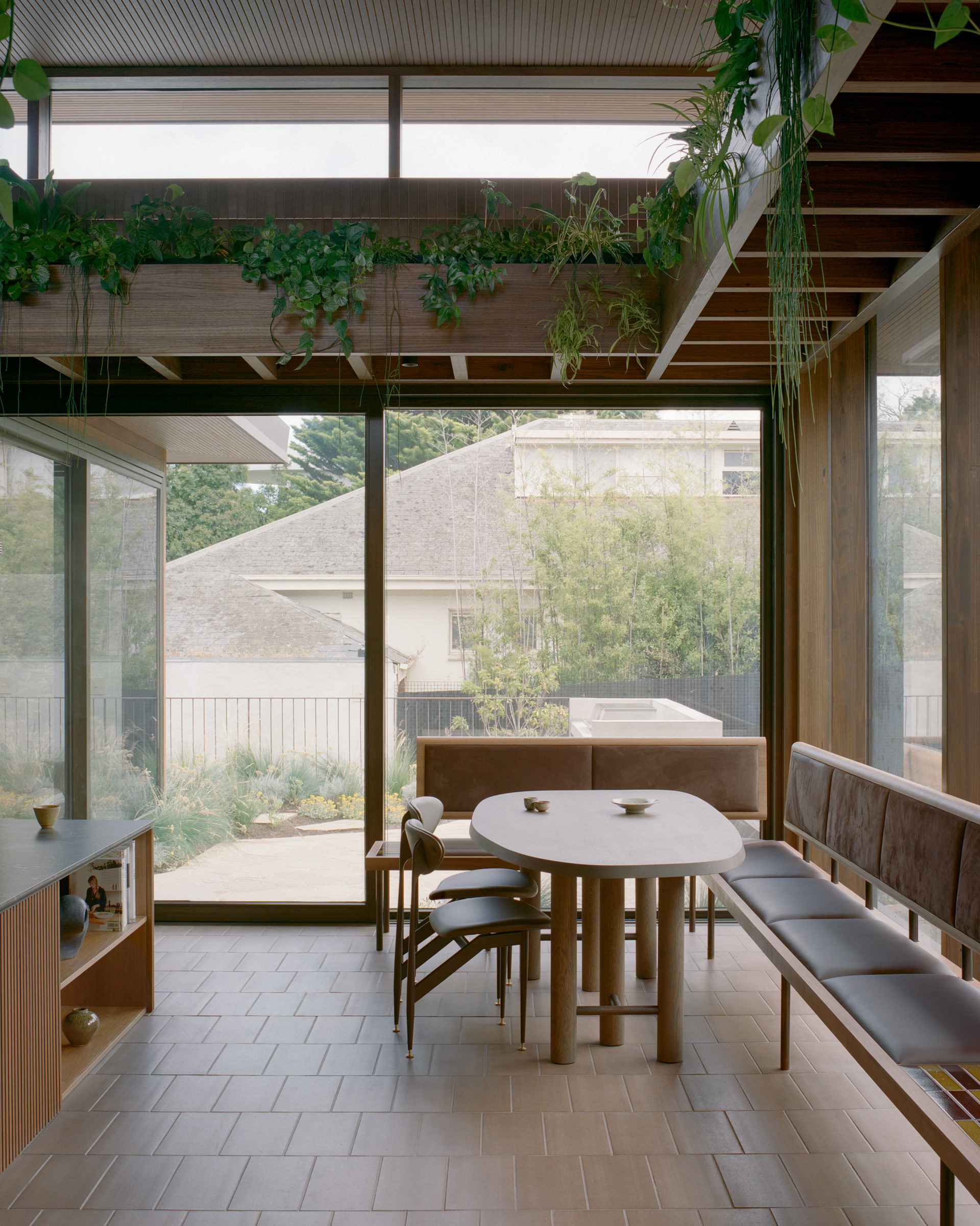 Dining nook beneath clerestory glazing and a suspended garden.