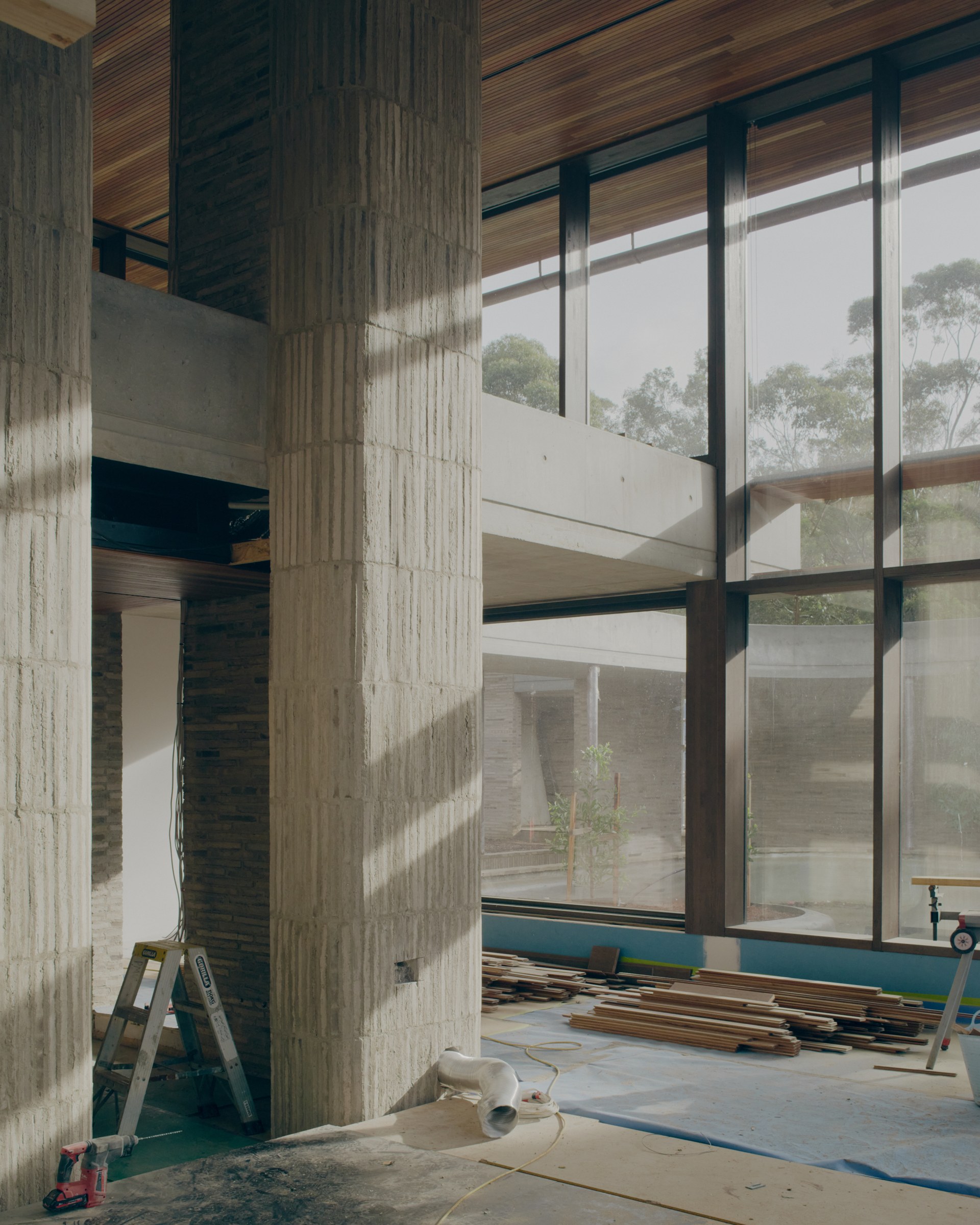 Full-height glazing beside a masonry column during construction.