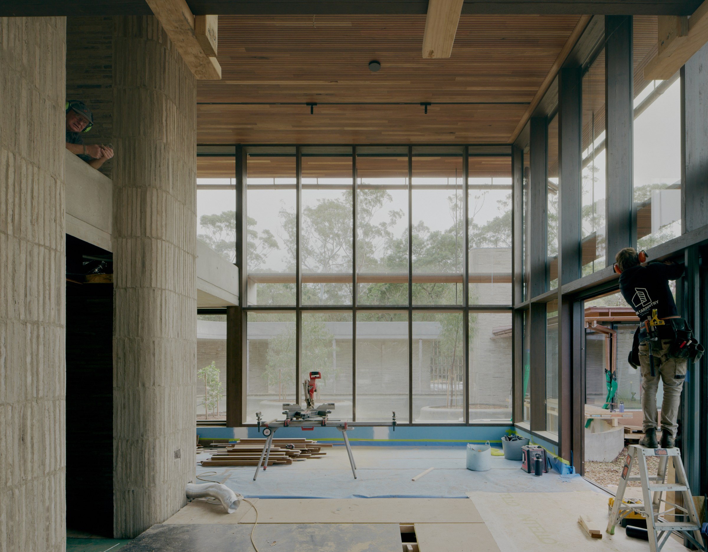 Exposed timber roof and glazed façade overlooking the landscape during construction.