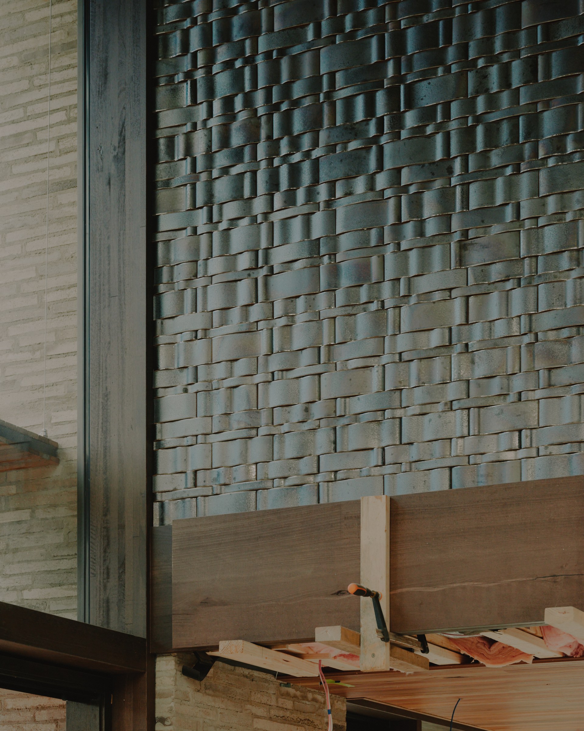 Textured masonry wall beneath the timber ceiling during construction.