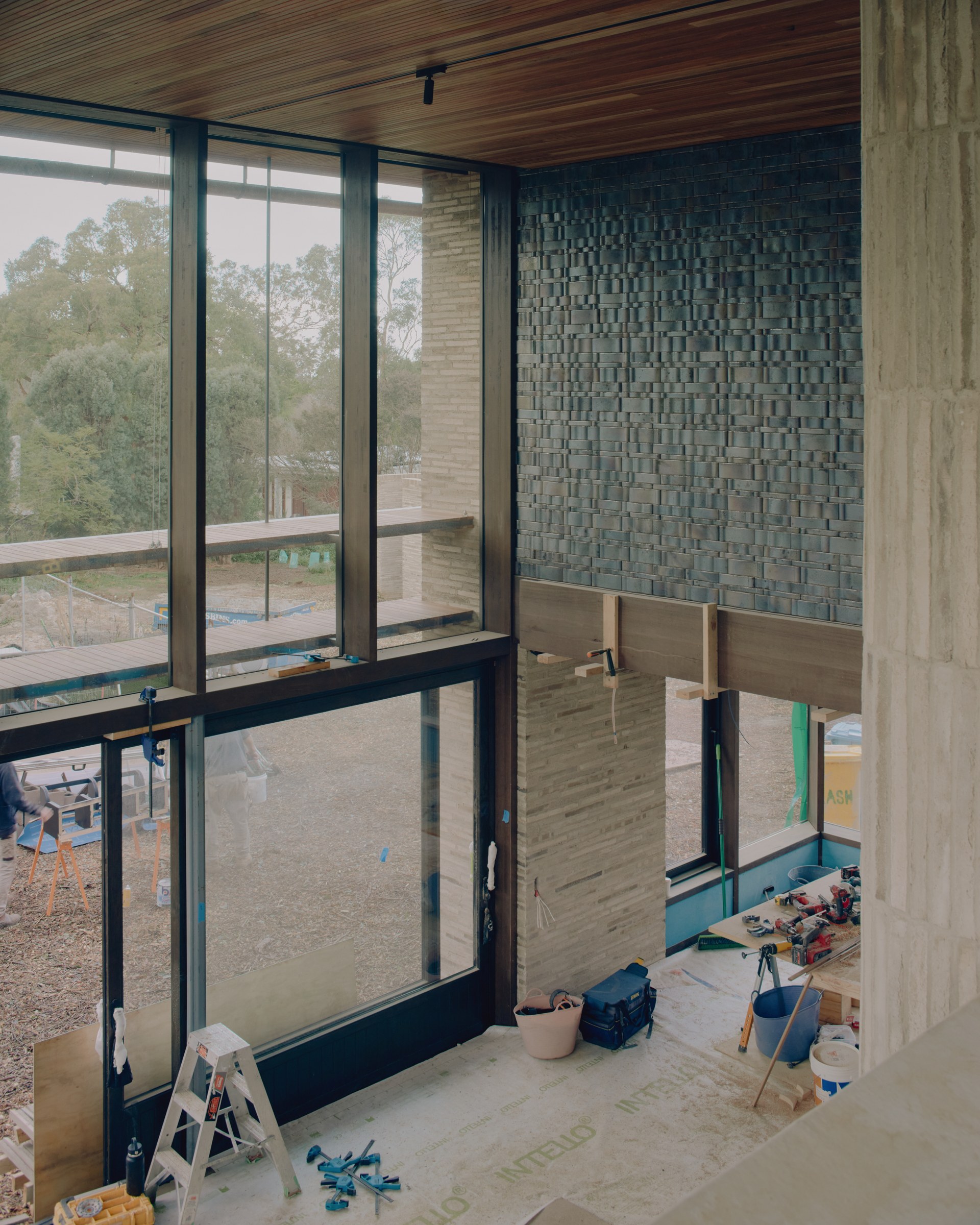 Upper-level view of timber framing and glazing during construction.