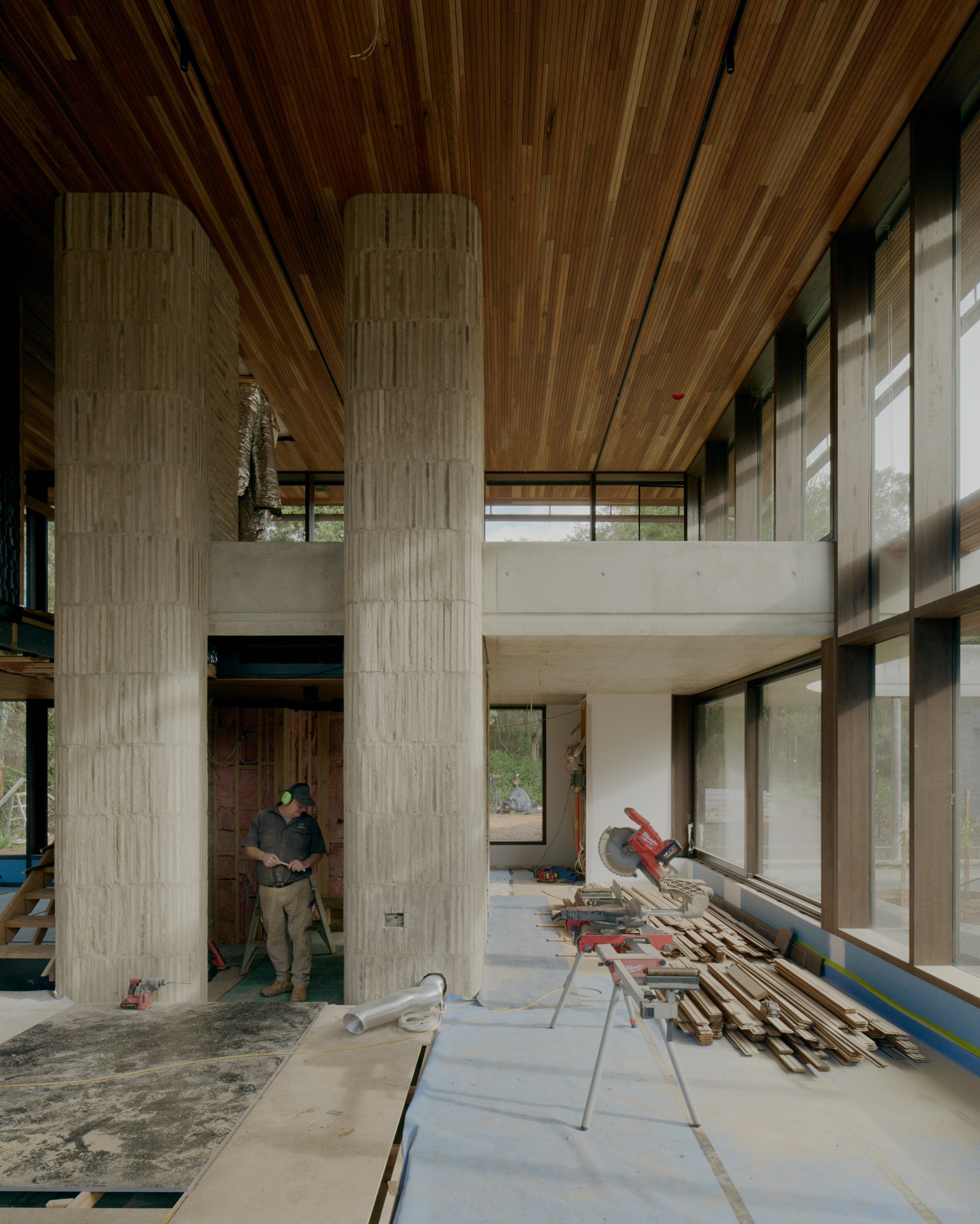 Exposed timber rafters above Anchor House’s double-height interior during construction.