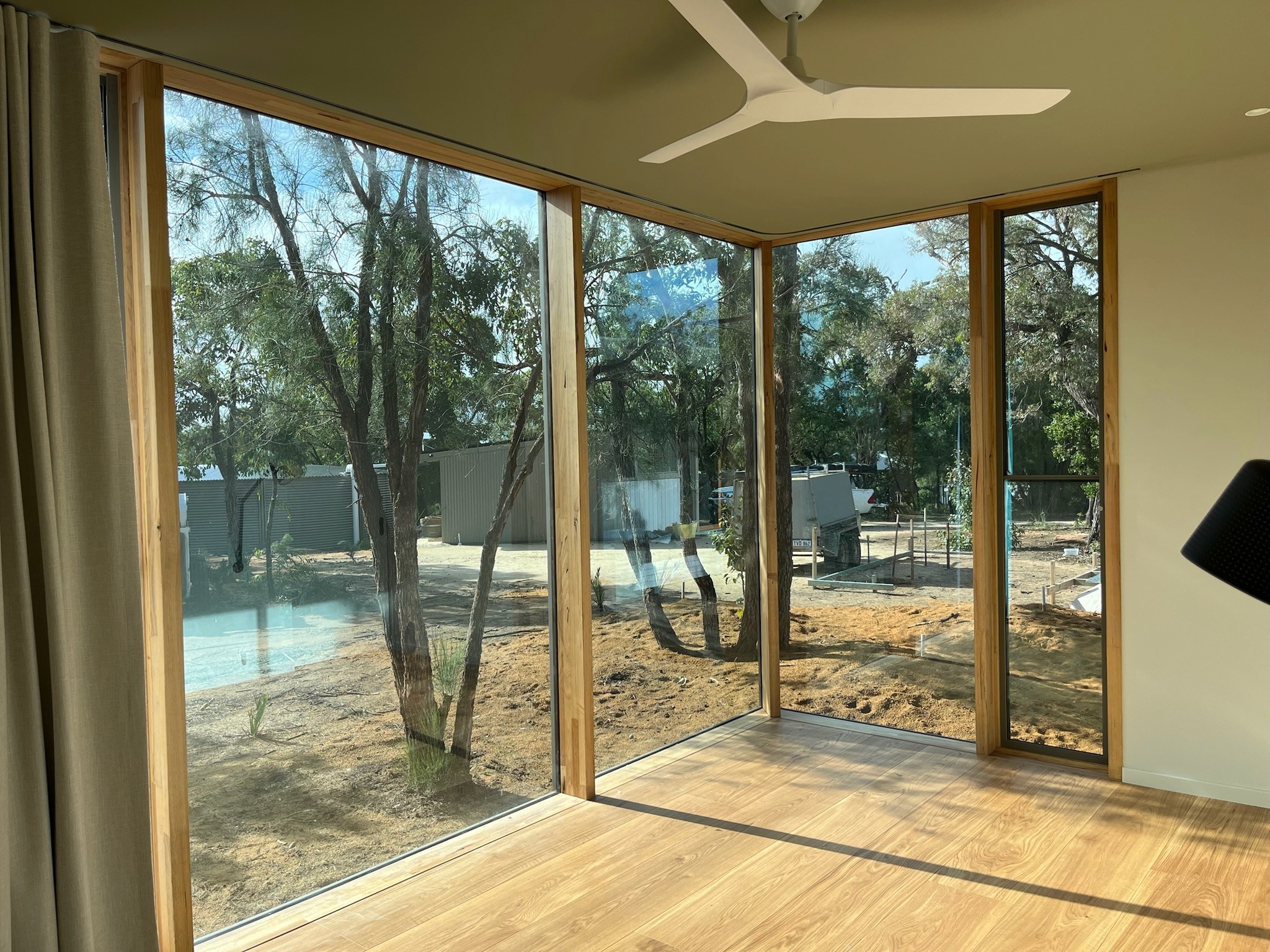 Large glazed openings connecting an interior room to the bushland.