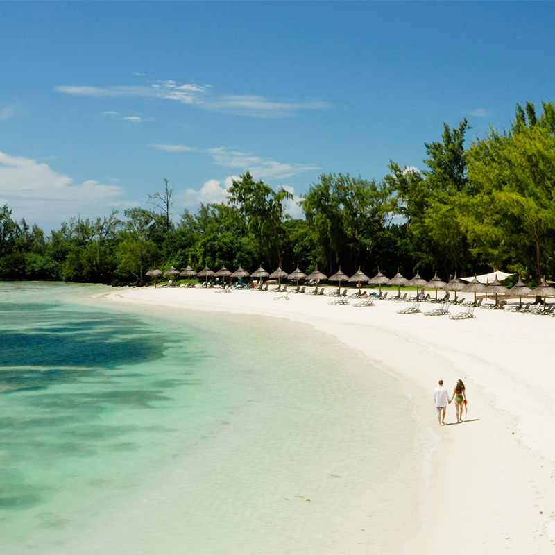 Couple walking along a white sandy beach