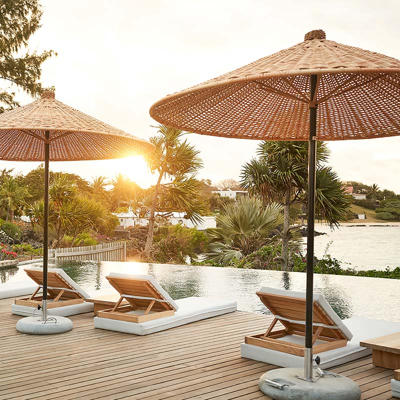 Sunbeds and pool at sunset