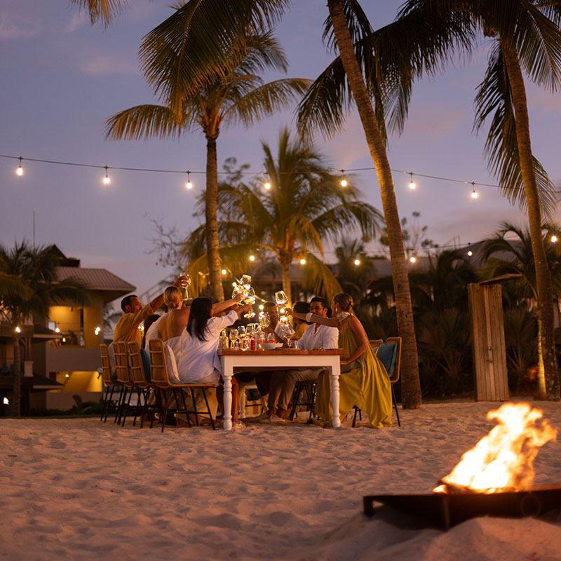 Family dining on the beach at night