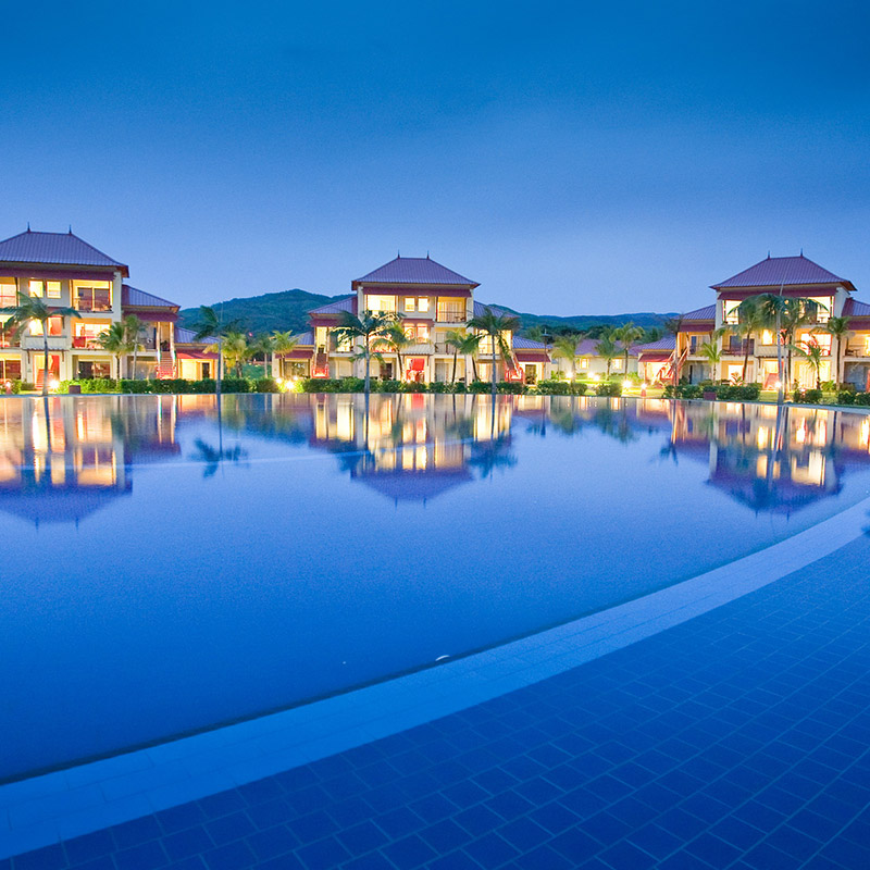 Night view of the rooms reflecting off the pool.