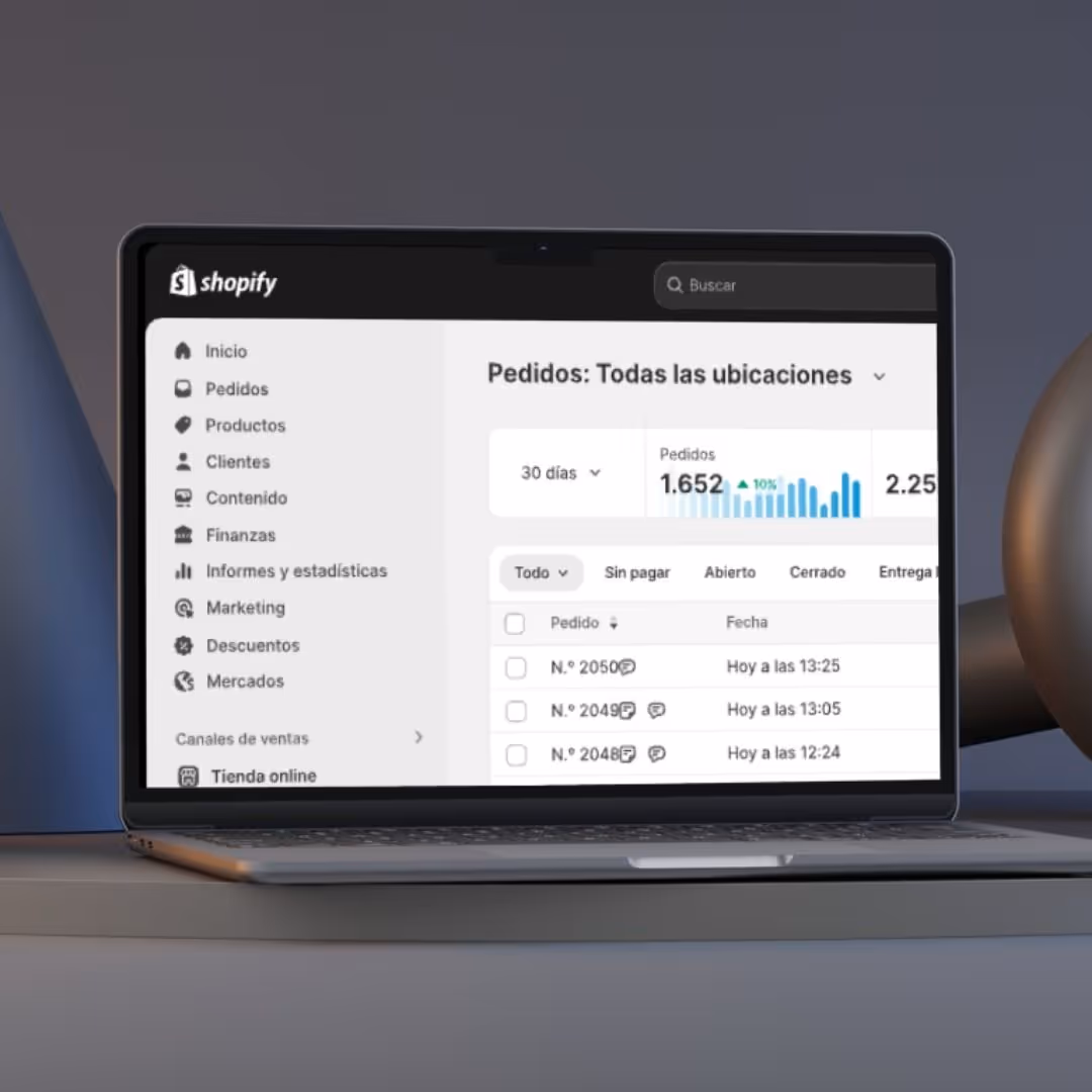 Portátil mostrando el panel de control de Shopify con un resumen de pedidos, menú lateral con opciones como Inicio, Pedidos, Productos y Marketing.