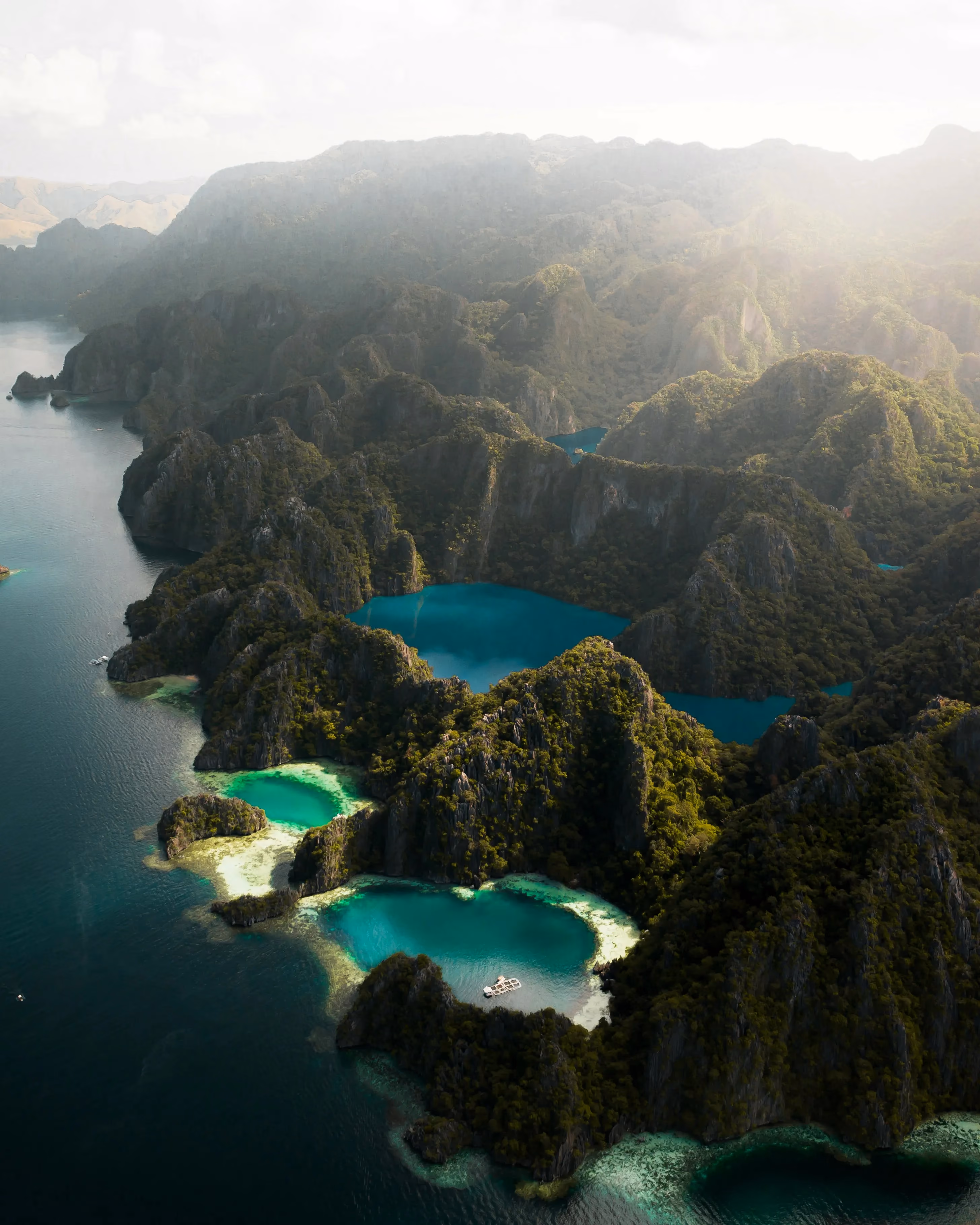 Morning light bursting through the misty clouds over Barracuda Lake - Coron Island, Palawan Province, Philippines.
