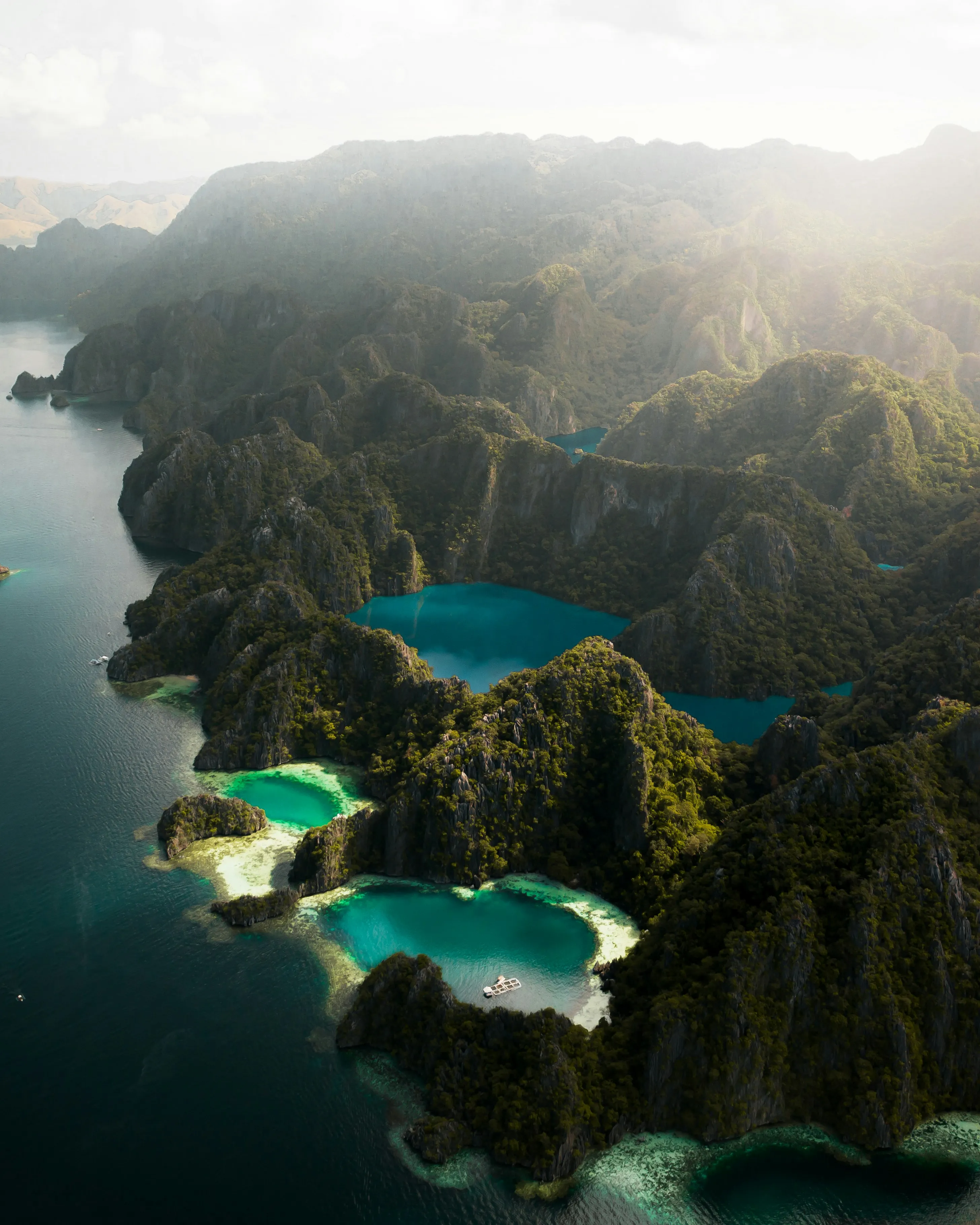 Morning light bursting through the misty clouds over Barracuda Lake - Coron Island, Palawan Province, Philippines.