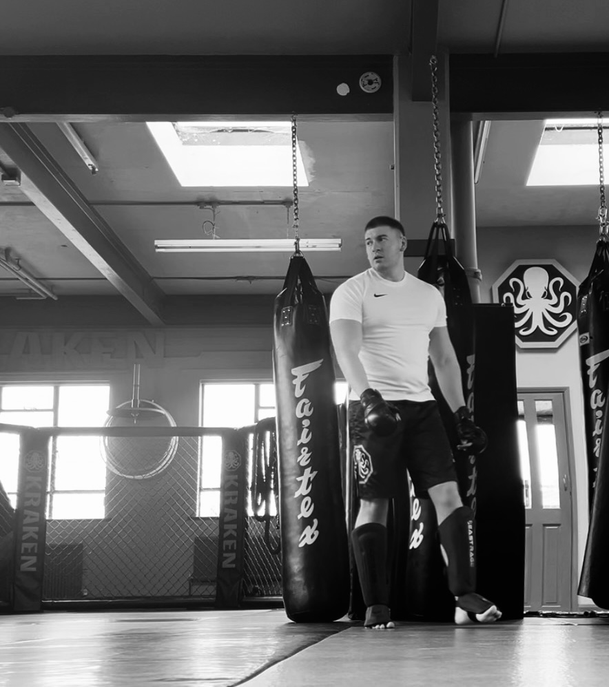 Luke McIntosh Standing in a gym in MMA Gear