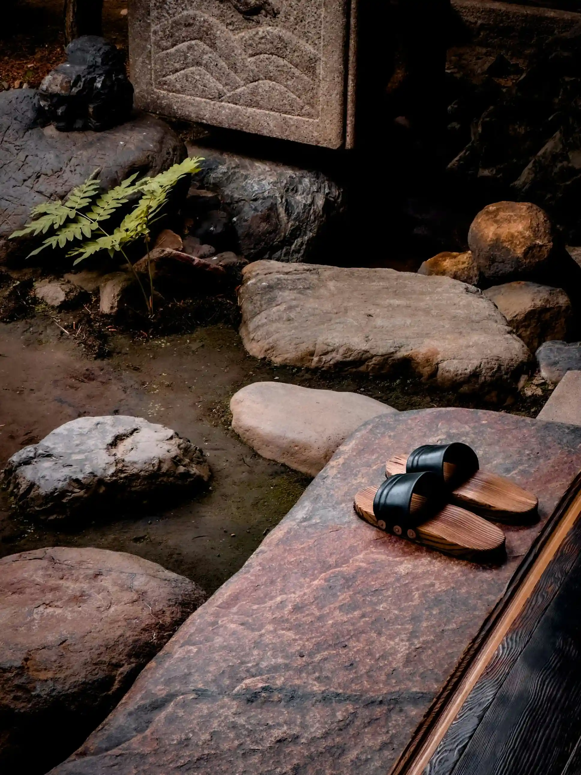 A pair of sandals next to a traditional fountain