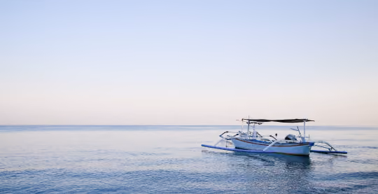 Jukung Fishing boat on the ocean at sunset.