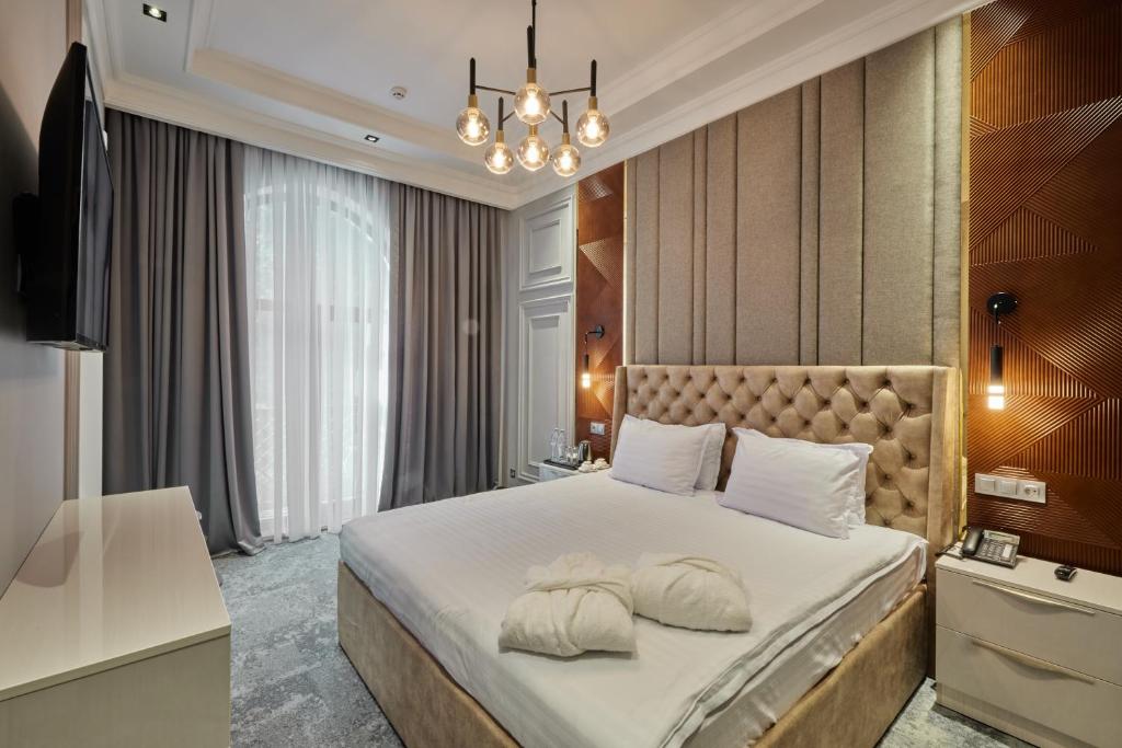a bedroom with a large bed with two pillows on it at Continental Hotel Samarkand in Samarkand