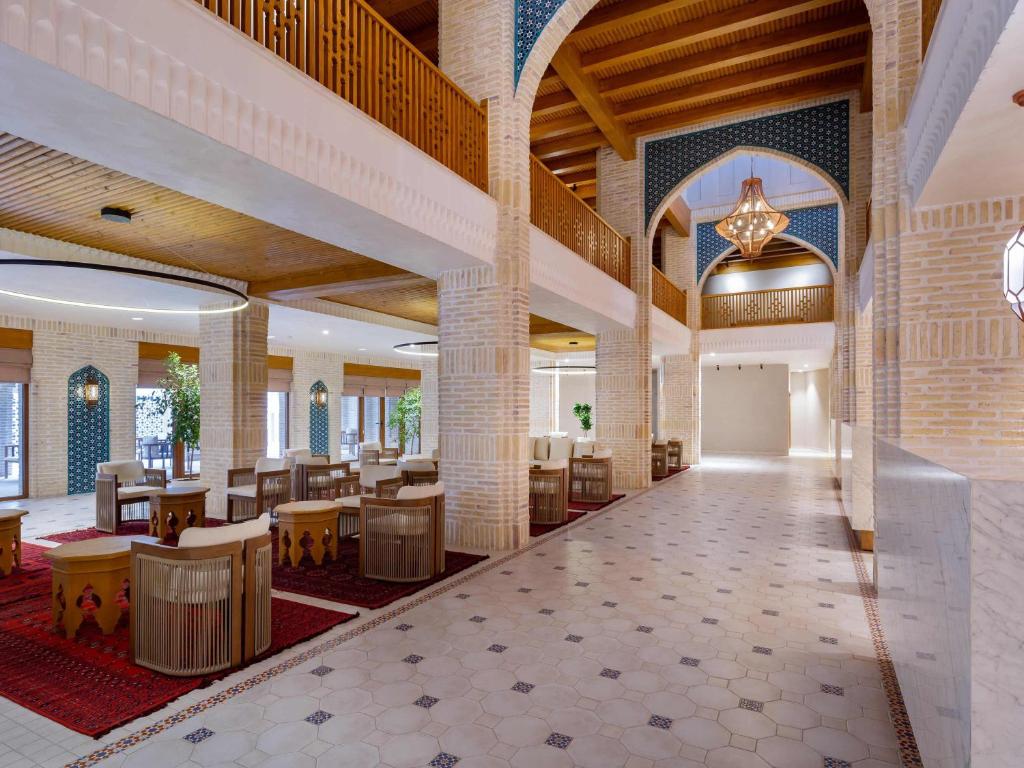 a lobby of a hotel with tables and chairs at Mercure Bukhara Old Town in Bukhara