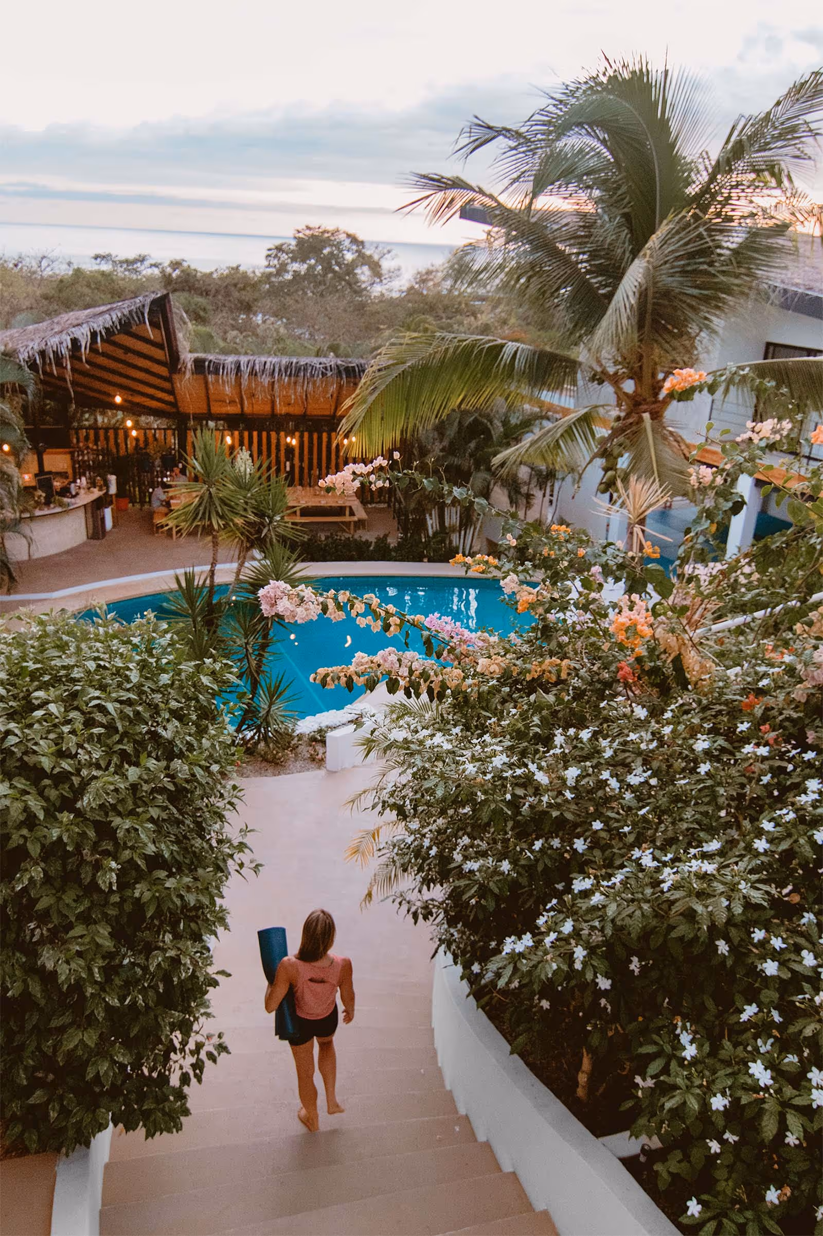 Girl walking through retreat center with yoga mat