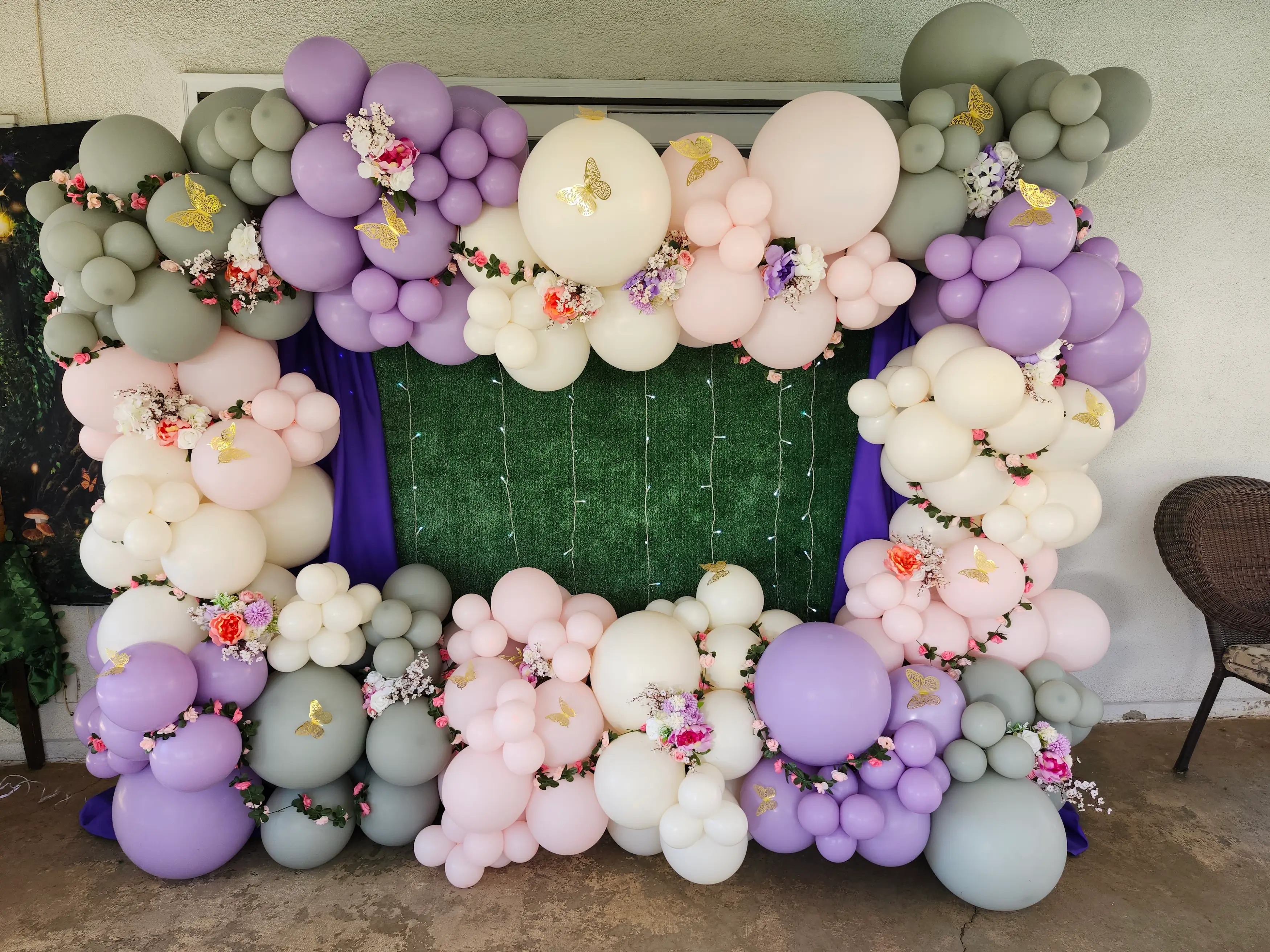Pastel balloon backdrop with floral accents and butterfly decor for kids birthday party in Inland Empire