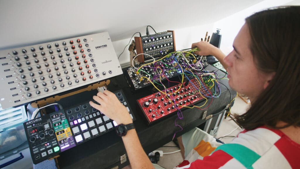 j03l press shot in the studio working on a track using modular