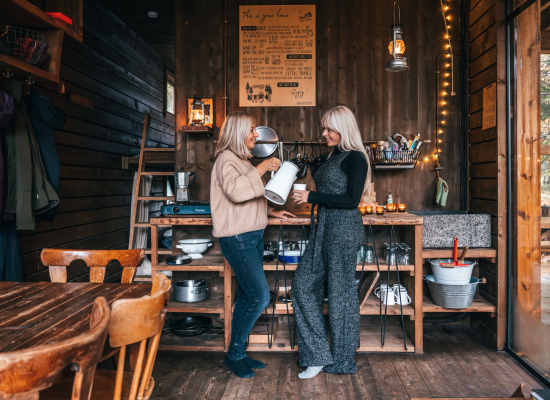A mother and her daughter drinking tea and planning their stay at Nutchel with a list of the best activities to do in the Ardennes