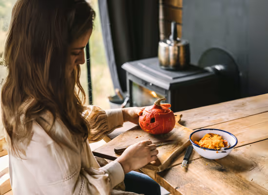 A Nutchel guest testing an autumn DIY idea which is pumpkin carving, in front of the woodst